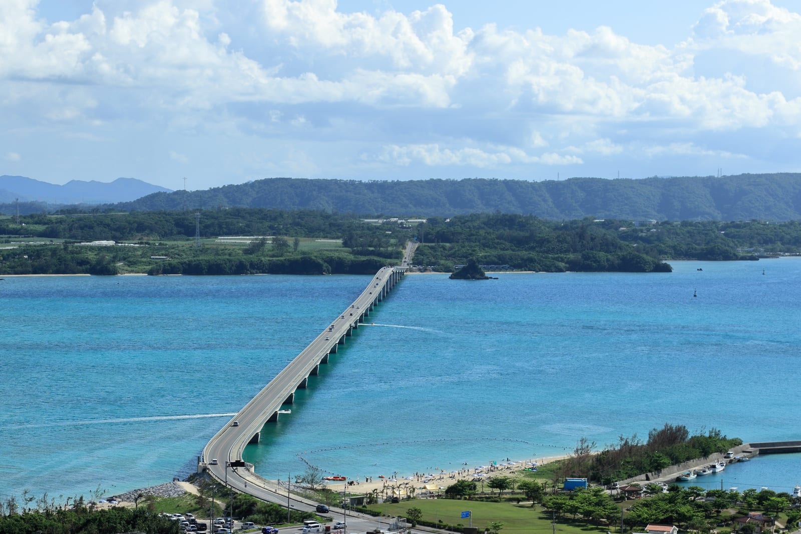 Kouri Island and the bridge connecting it to Okinawa are shown across bright blue water.