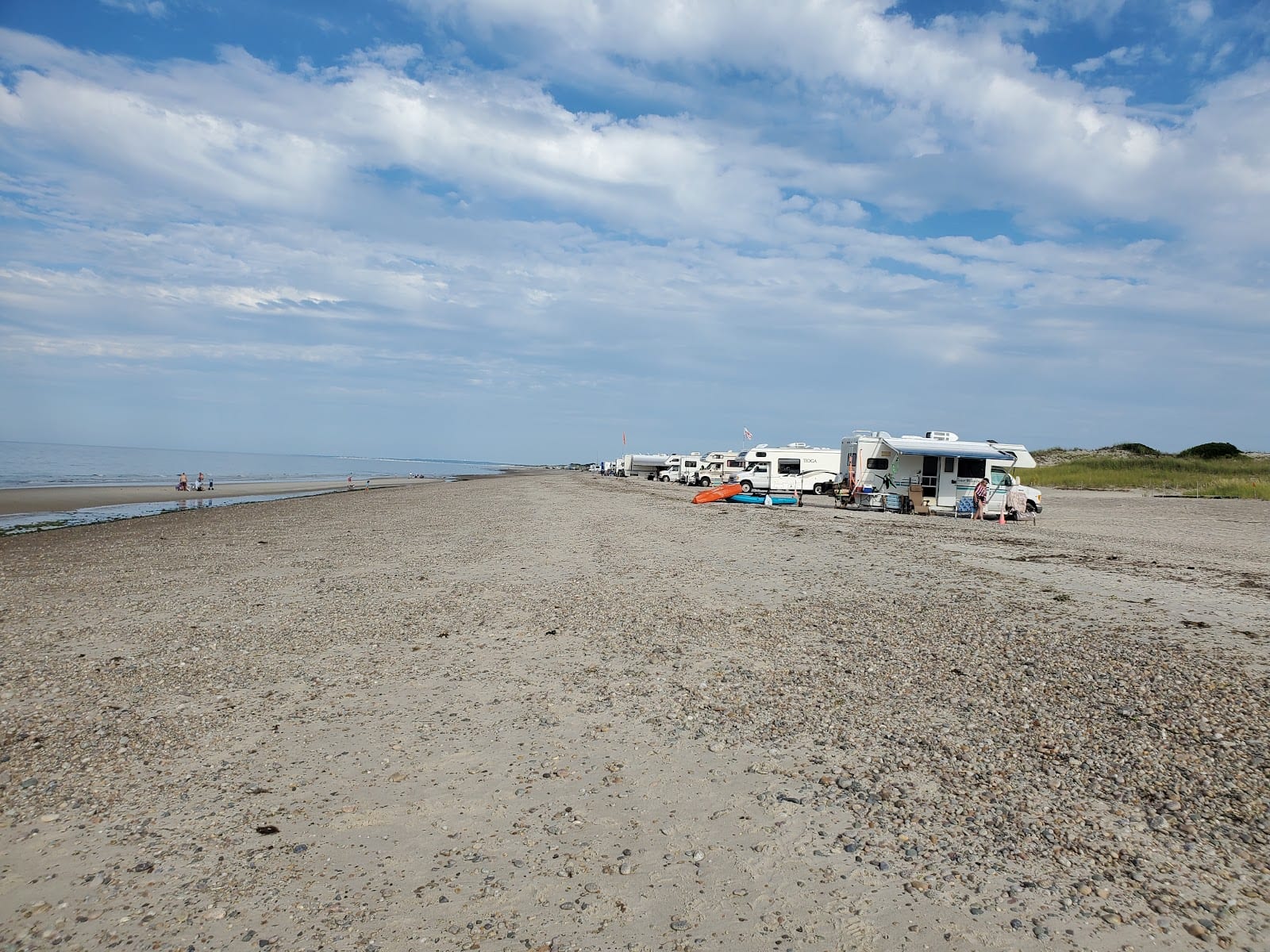 Oversand vehicles parked along the sand on the six-mile barrier beach at Sandy Neck.