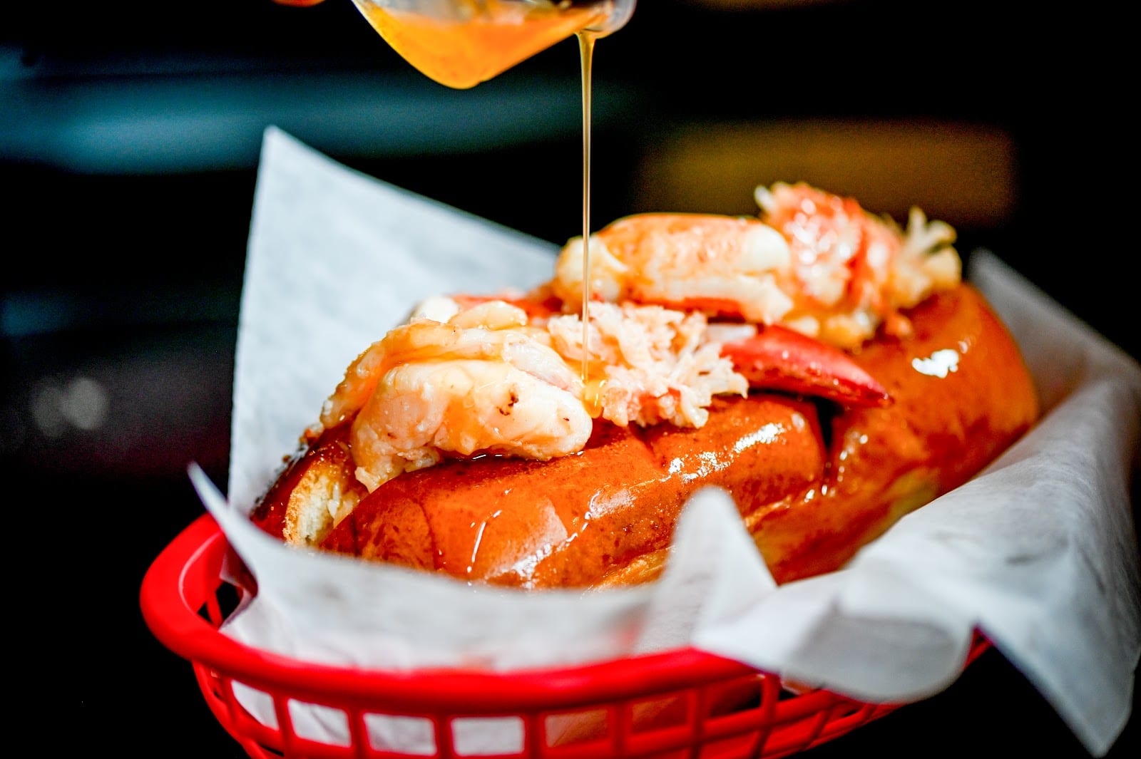 A lobster roll overflowing with chunks of lobster meat in a toasted split-top bun.