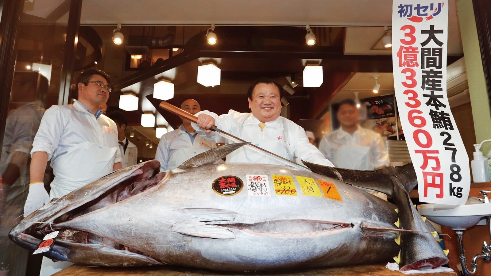 Sushizanmai's owner holding up a prize Oma bluefin tuna from the New Year auction.