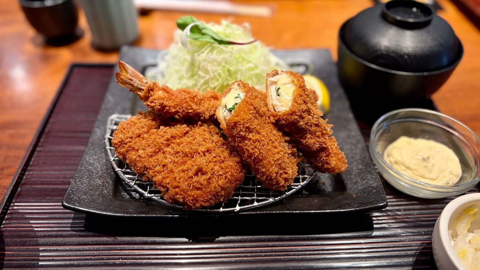 A platter of tonkatsu and fried prawns with a mound of shredded cabbage.