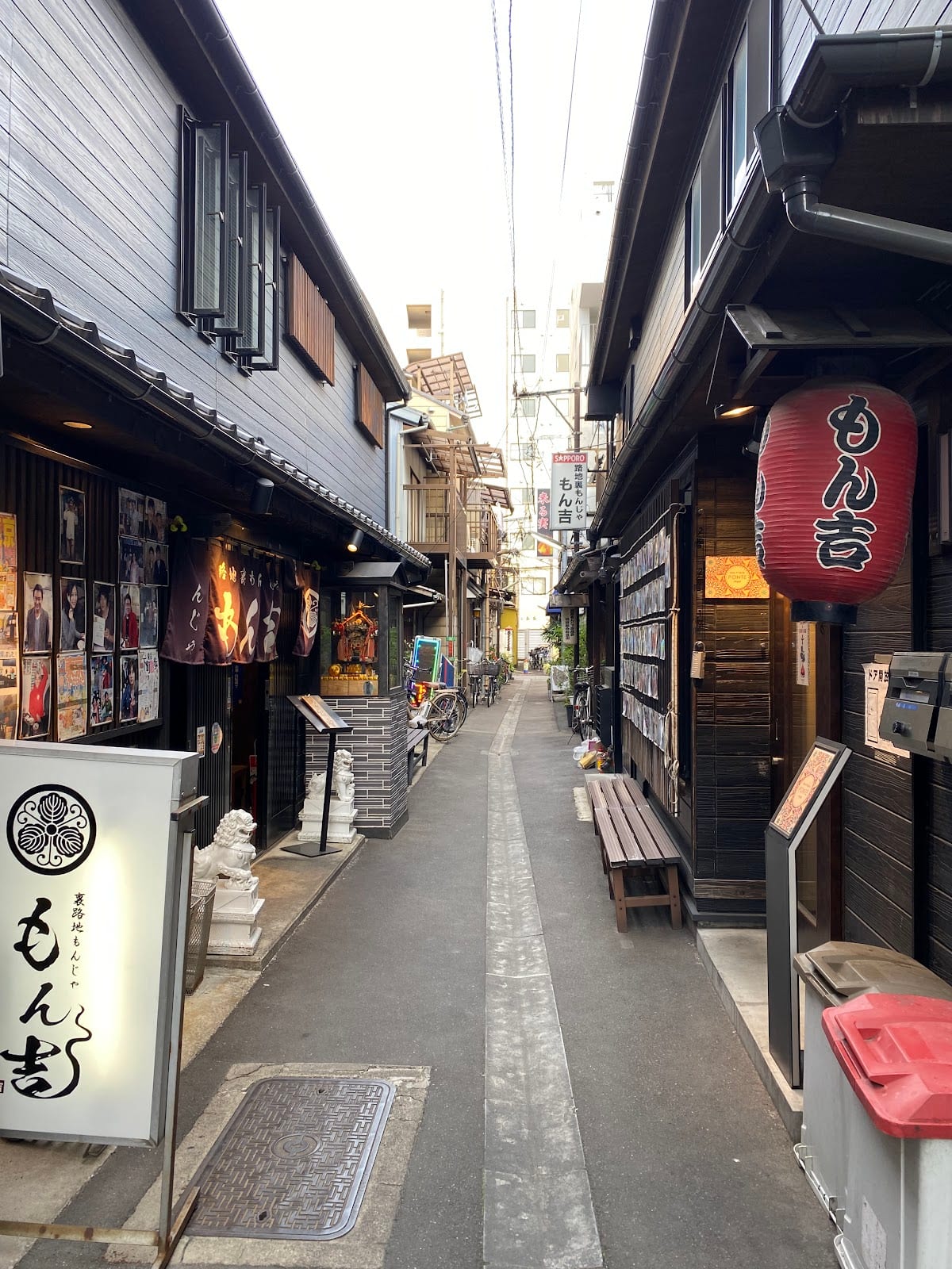 A side lane off Tsukishima's Monja Street with a red-lanterned monja shop.