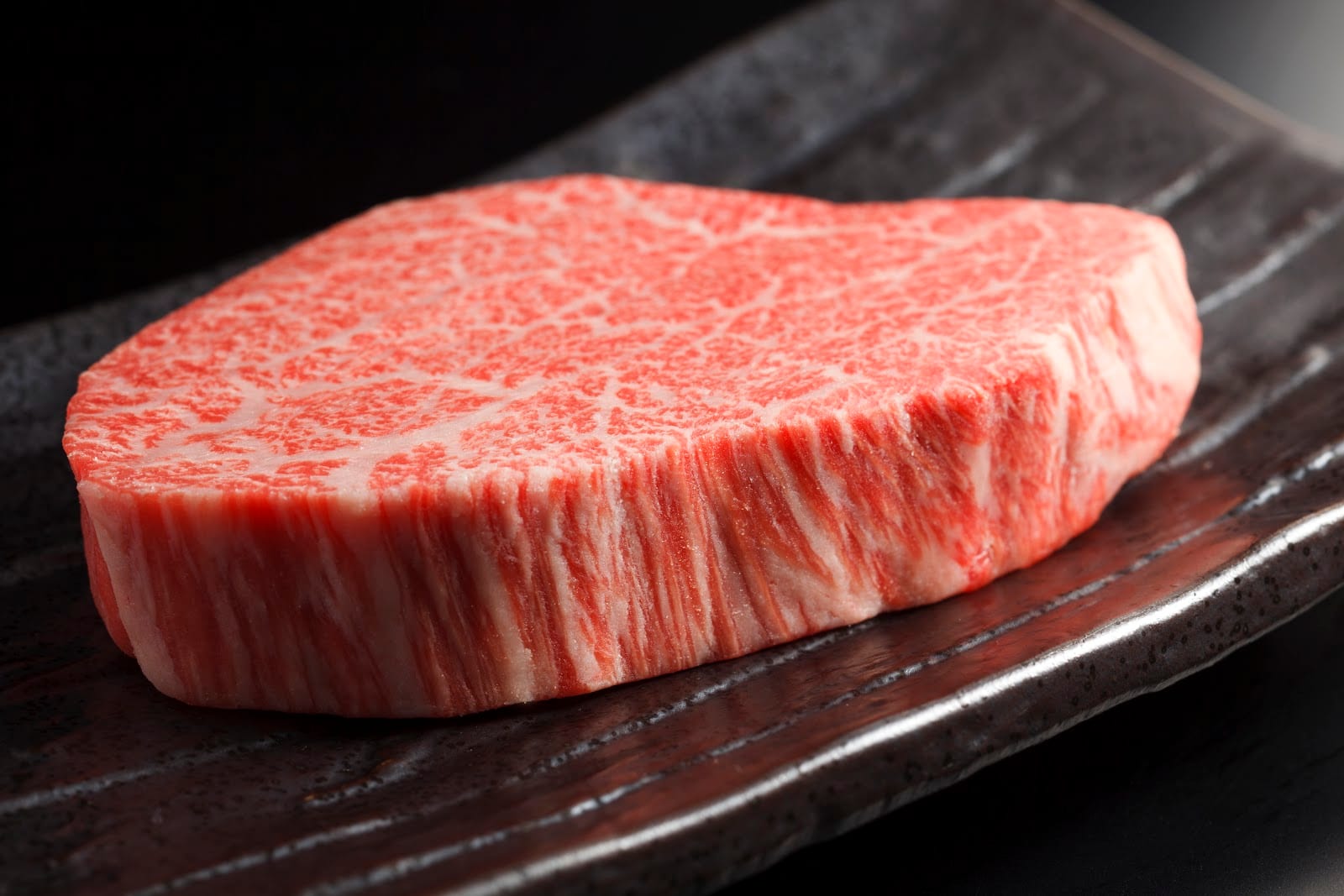 A thick cut of marbled wagyu beef ready for the grill at Yakiniku Jumbo.