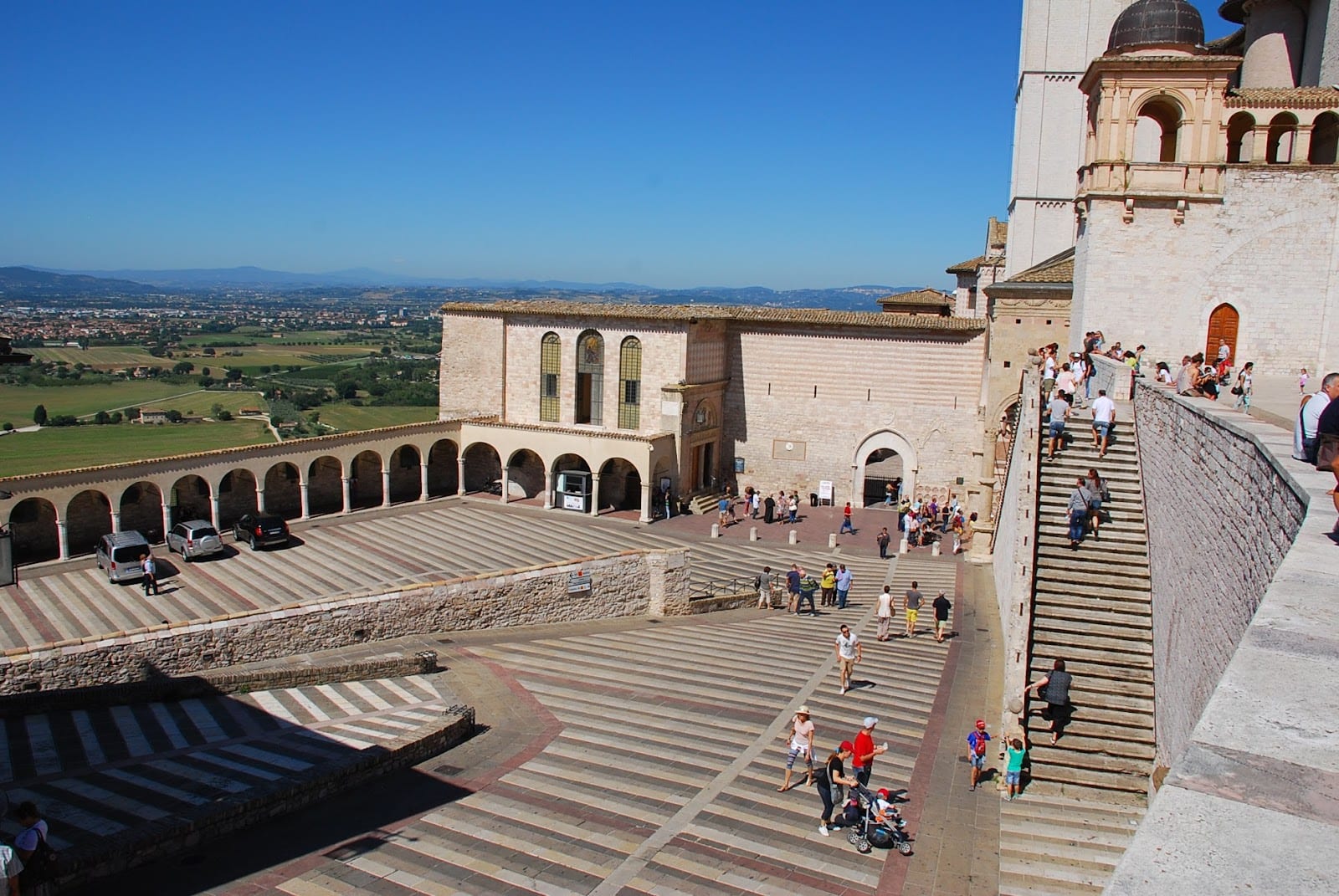 The sloping plaza and steps below the Basilica of St Francis, with the valley beyond.
