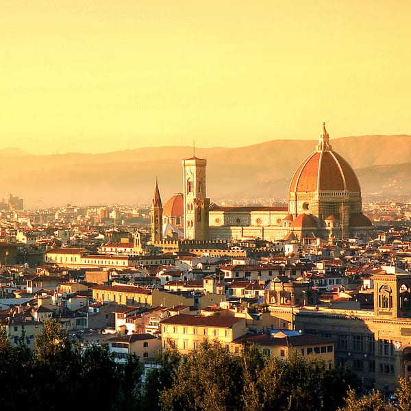 Florence's terracotta dome and bell tower above the city rooftops at golden hour.