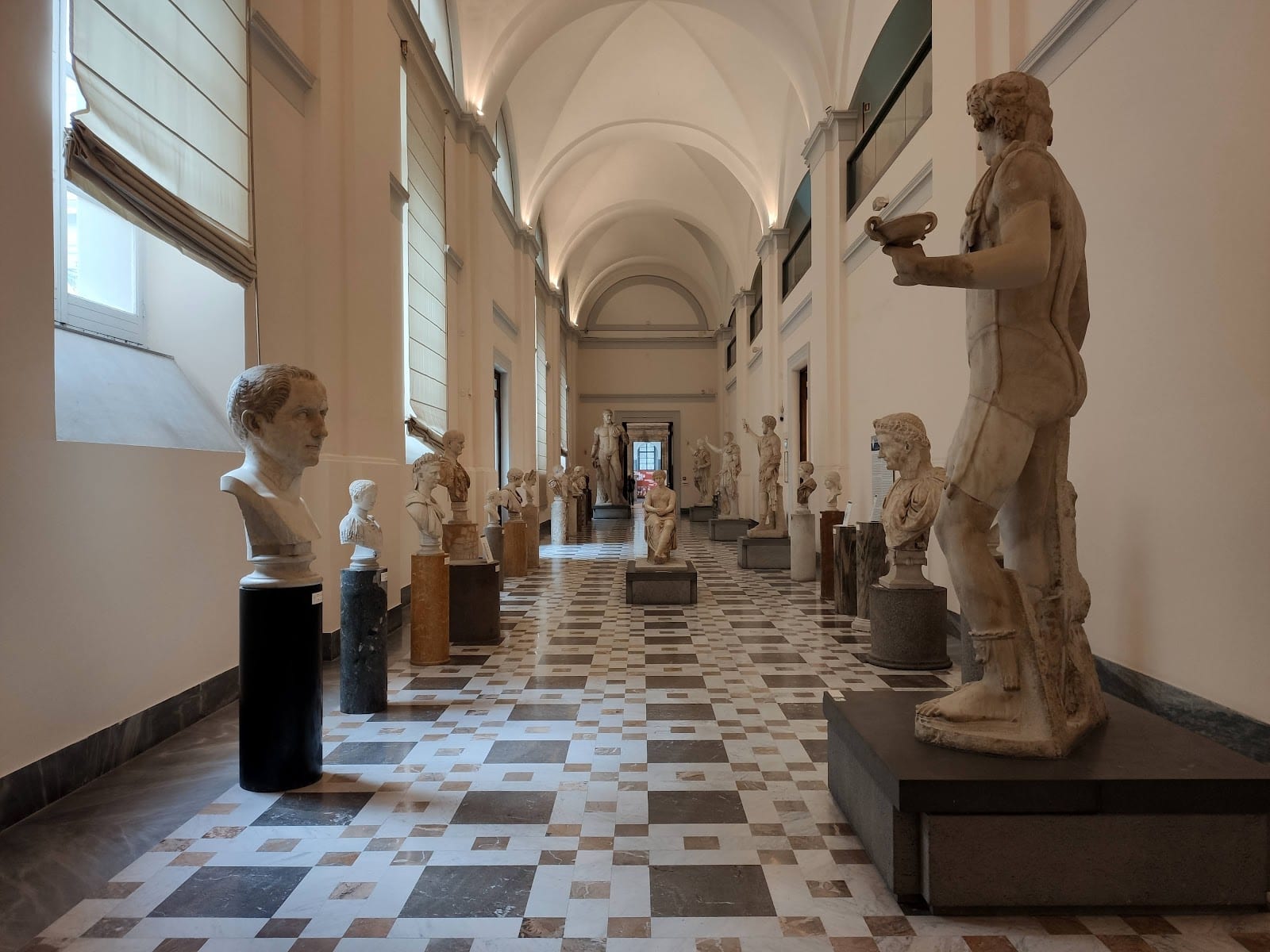 The sculpture gallery of the National Archaeological Museum of Naples, lined with Roman statues.