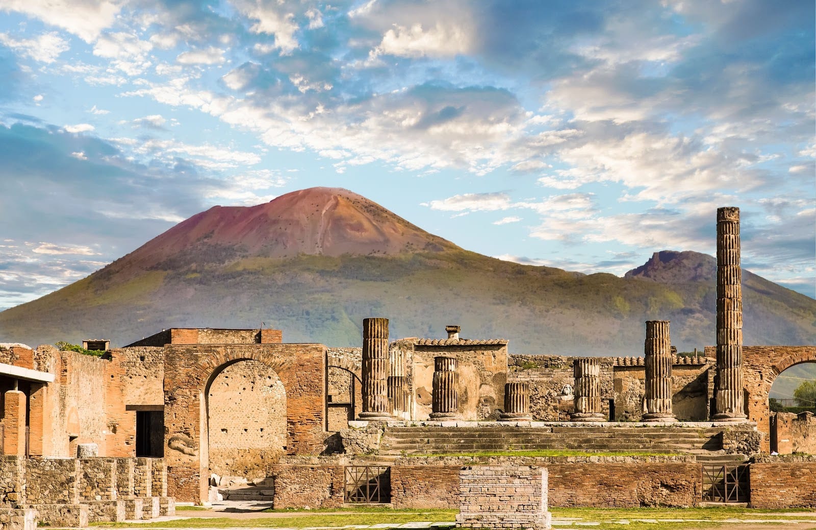 The ruins of Pompeii's forum with the cone of Mount Vesuvius rising behind them.