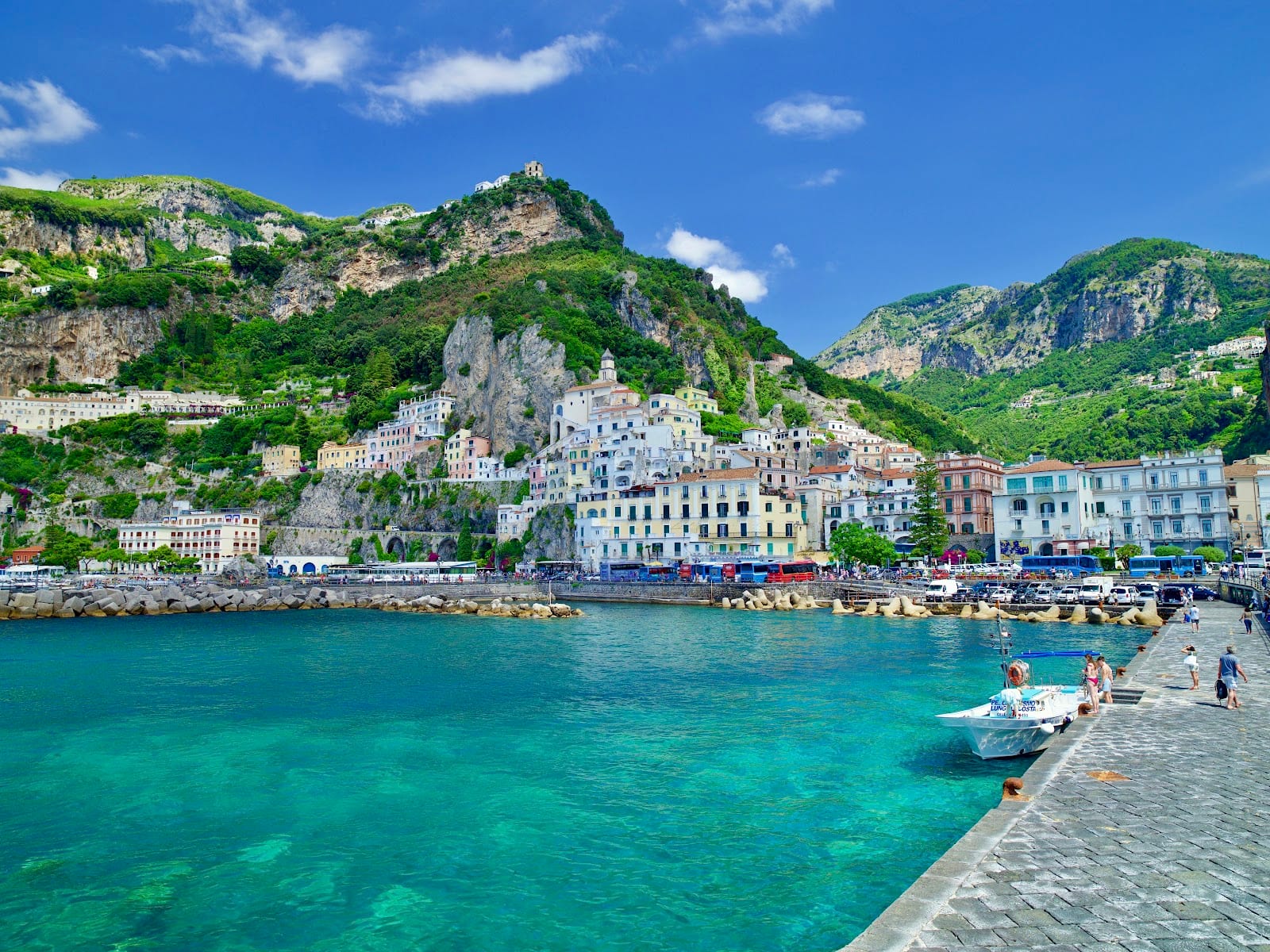 The town of Amalfi seen from the turquoise water below the coastal cliffs.