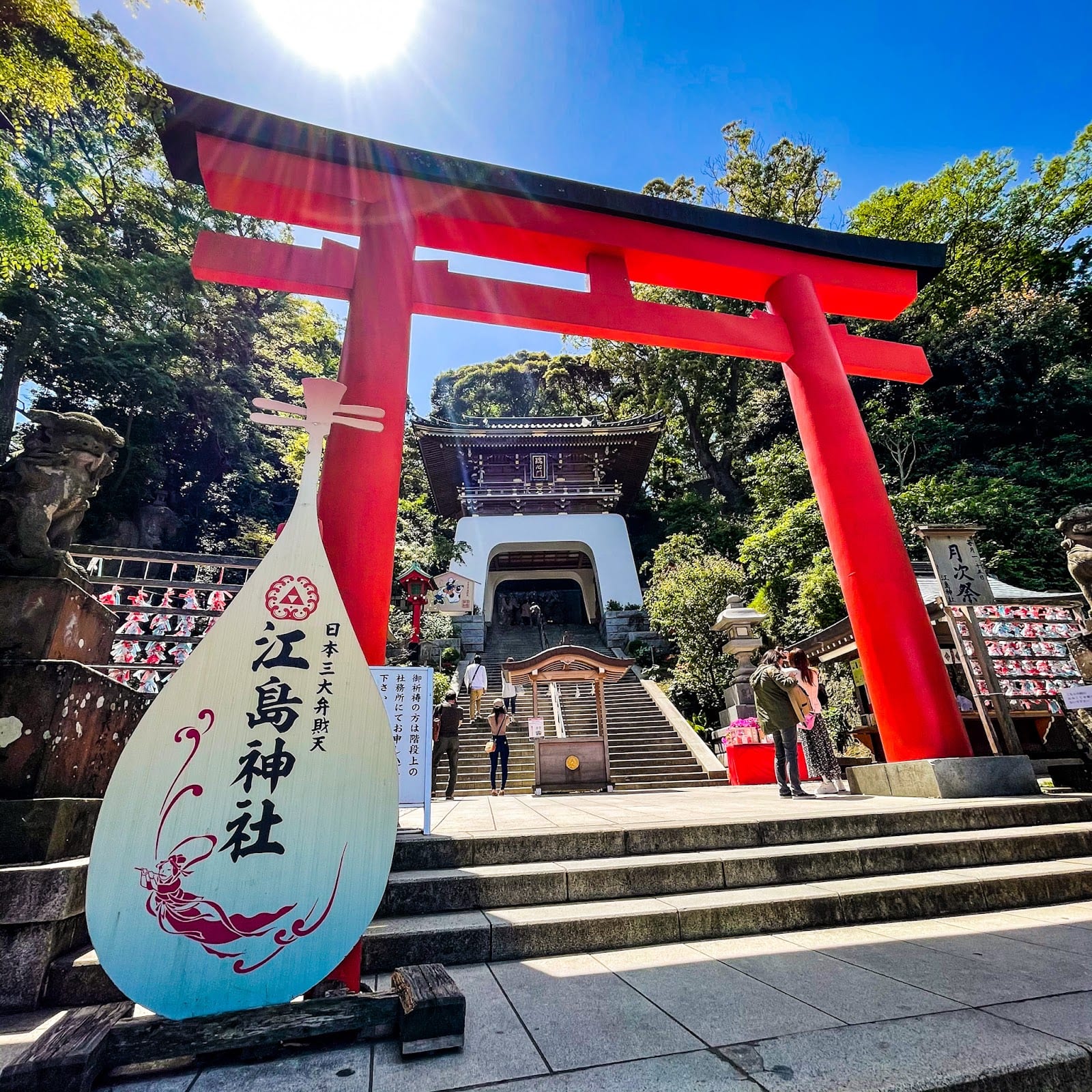 The red entrance torii and stairway up to Enoshima Shrine, with its carved name stone.