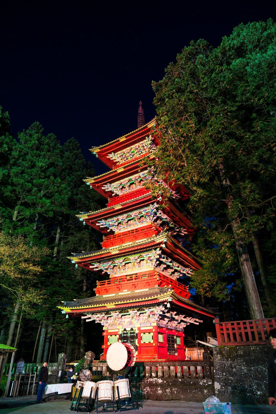 The vermilion five-storey pagoda at Nikko Toshogu among tall cedars.