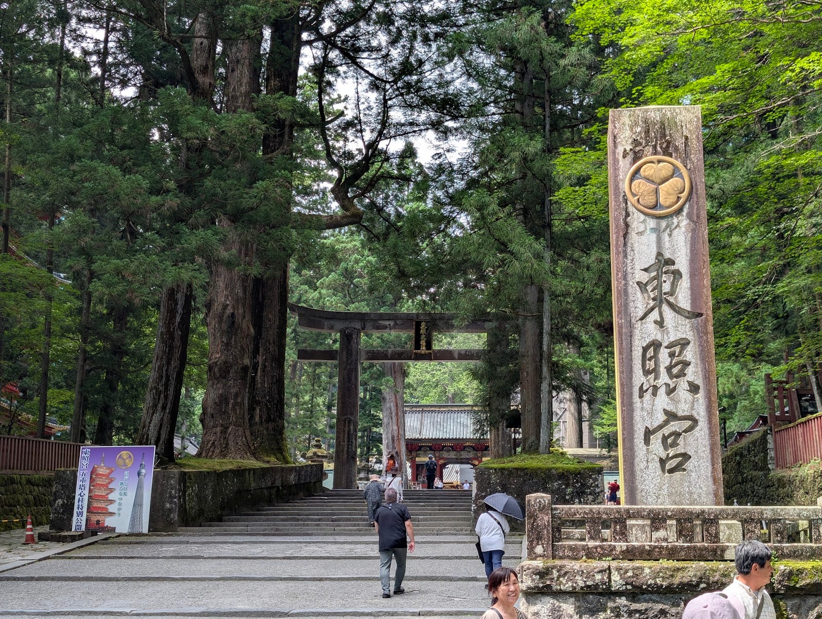 The stone torii and cedar-lined approach to Nikko Toshogu, with its carved stone name marker.