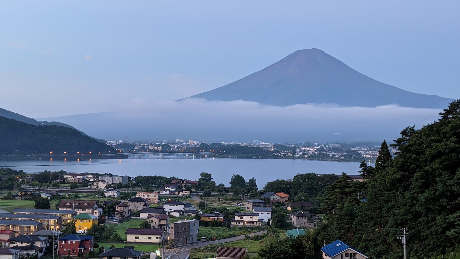 Mt. Fuji behind Kawaguchiko town with low morning cloud along its base.