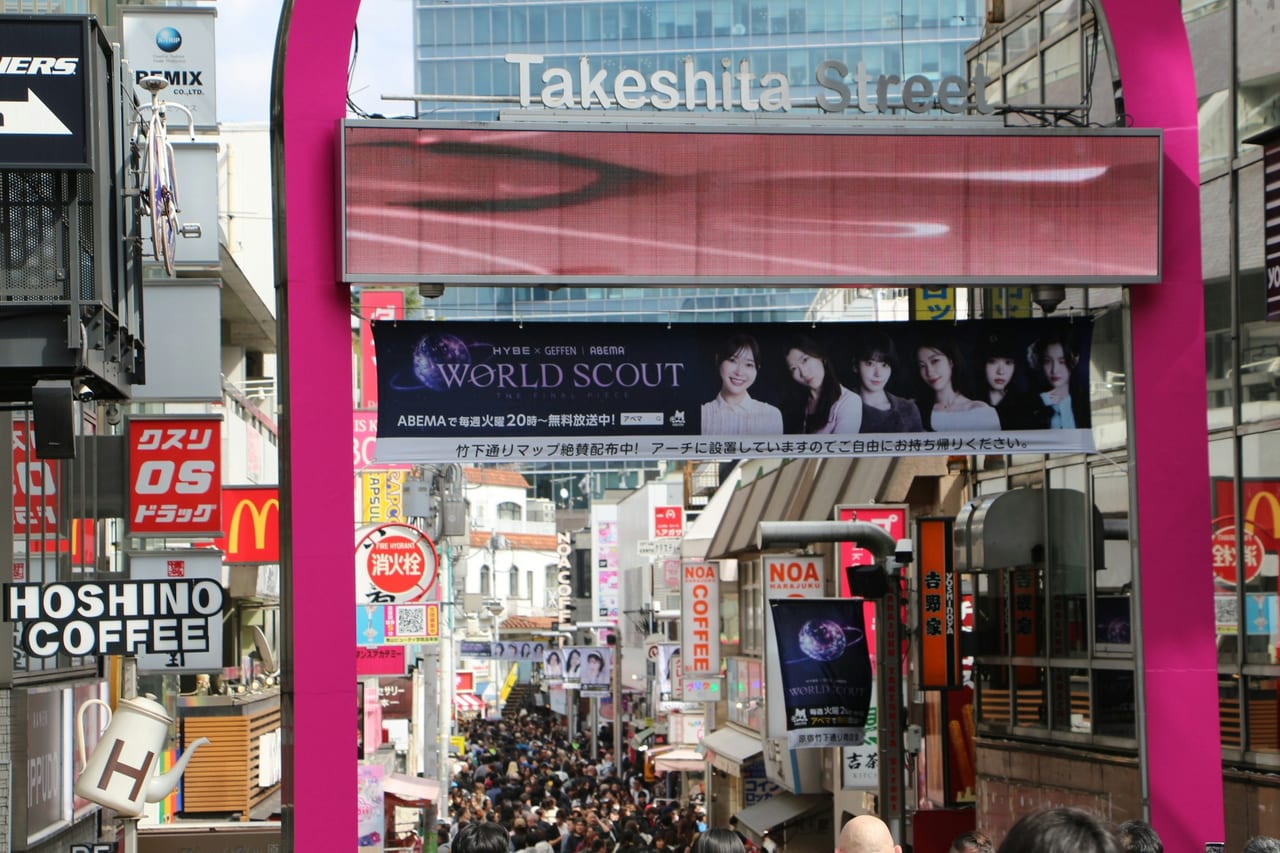 The arched Takeshita Street sign rises over the dense crowd flowing down Harajuku's teen-fashion lane.