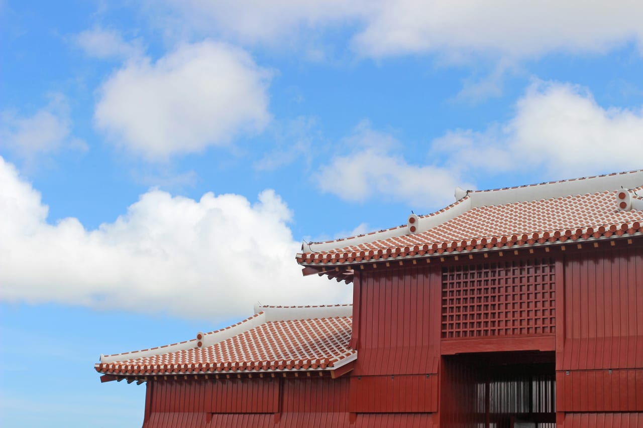 A red Okinawan-style tiled building beneath a blue sky.
