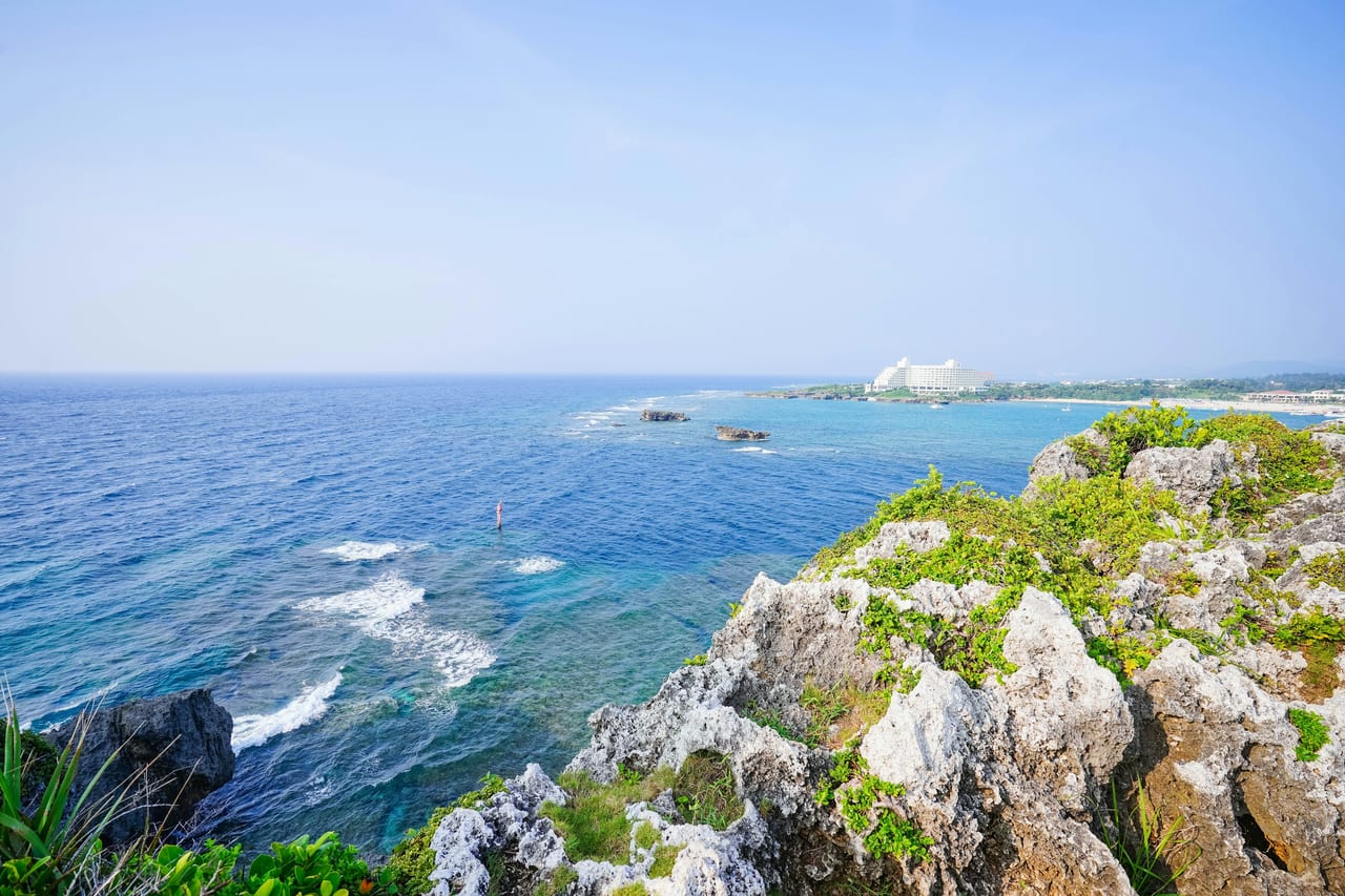 Rocky limestone cliffs border clear blue water along the coast.
