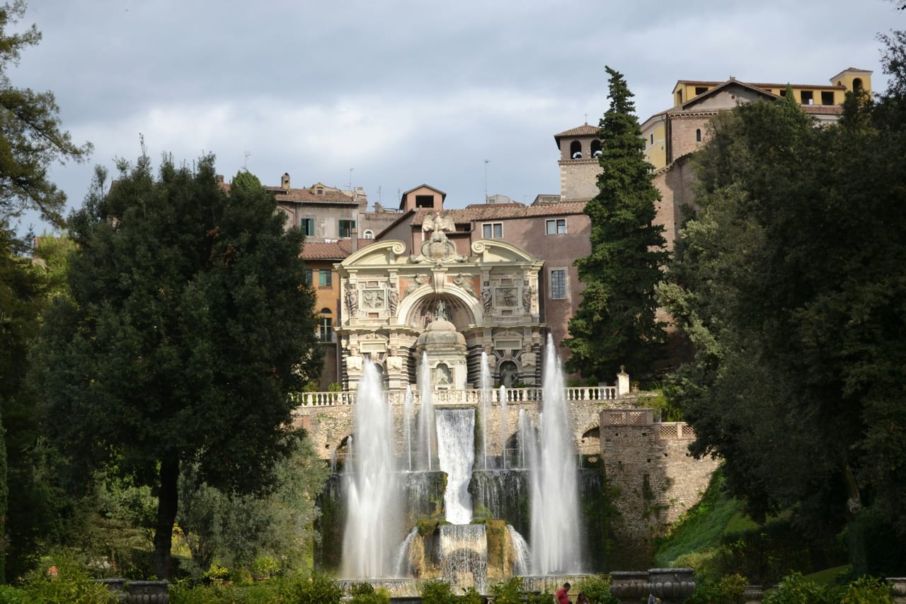 The tiered jets of the Neptune Fountain rise before the villa and hill town at Villa d'Este in Tivoli.