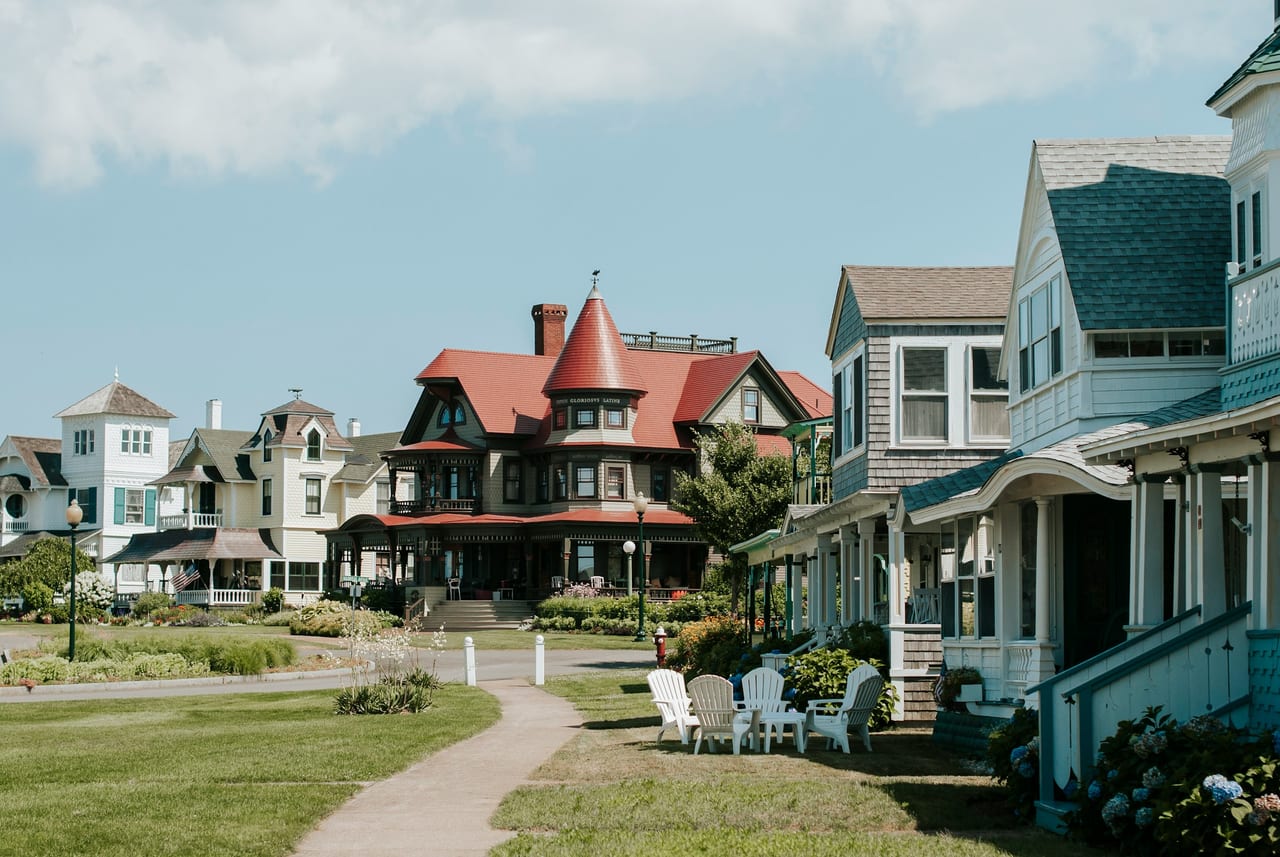 Colorful homes line a grassy walkway near the waterfront.