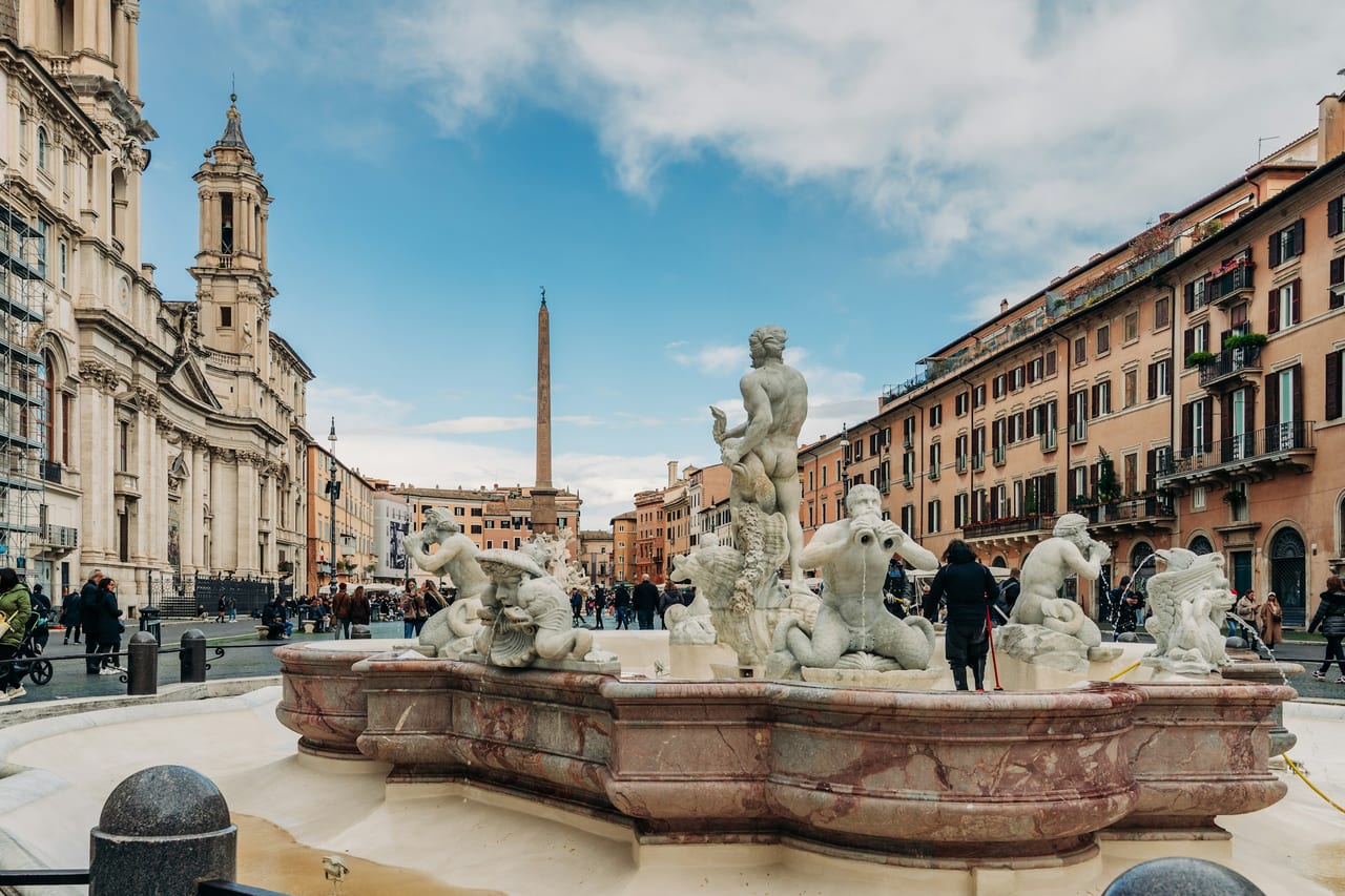 The Fountain of the Moor anchors Piazza Navona, with the obelisk and Sant'Agnese church beyond.