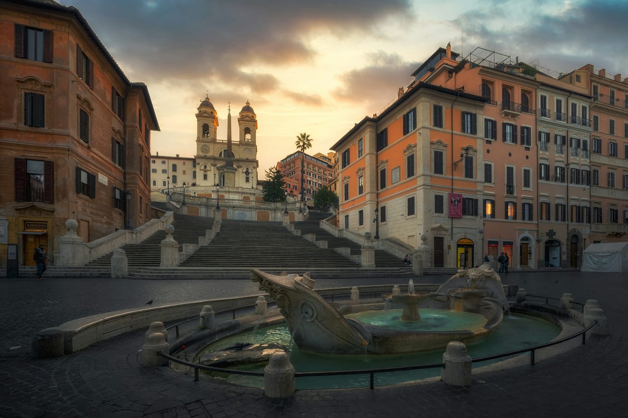 The empty Spanish Steps sweep up to the twin-towered church of Trinita dei Monti at dawn.