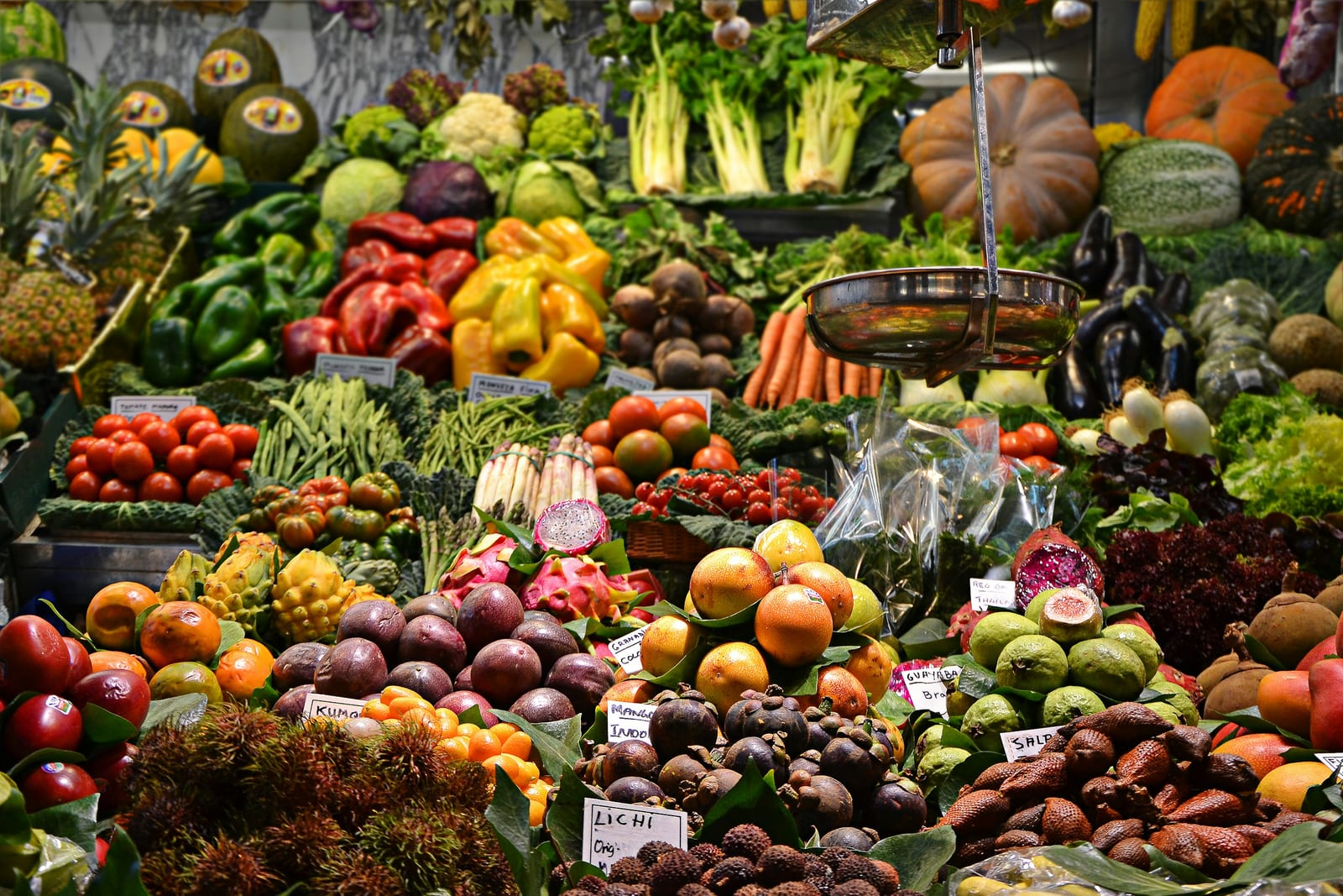 An indoor market hall with stalls of fresh produce and artisan goods.