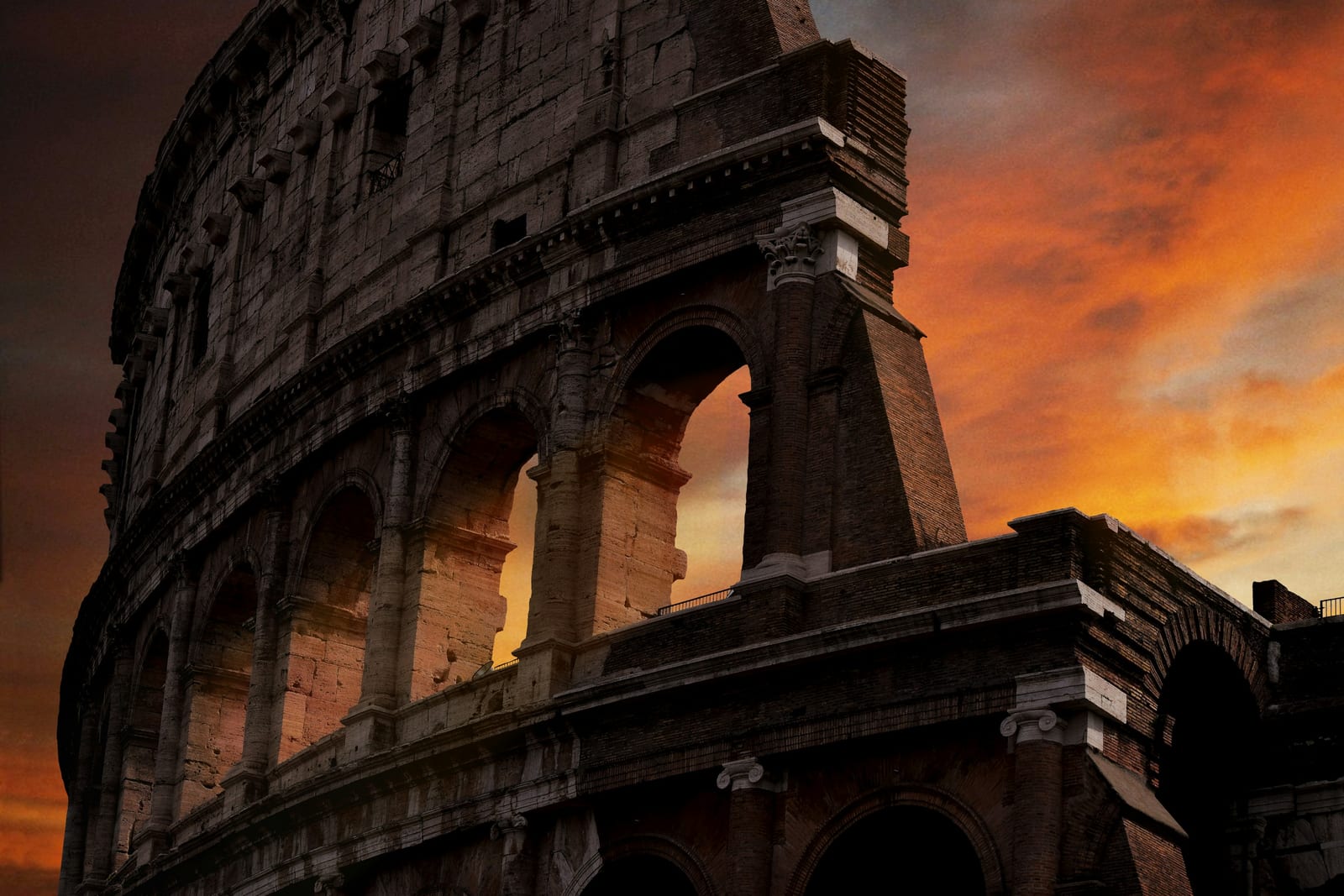 The Colosseum lit at dusk with an empty foreground under a moody winter sky.