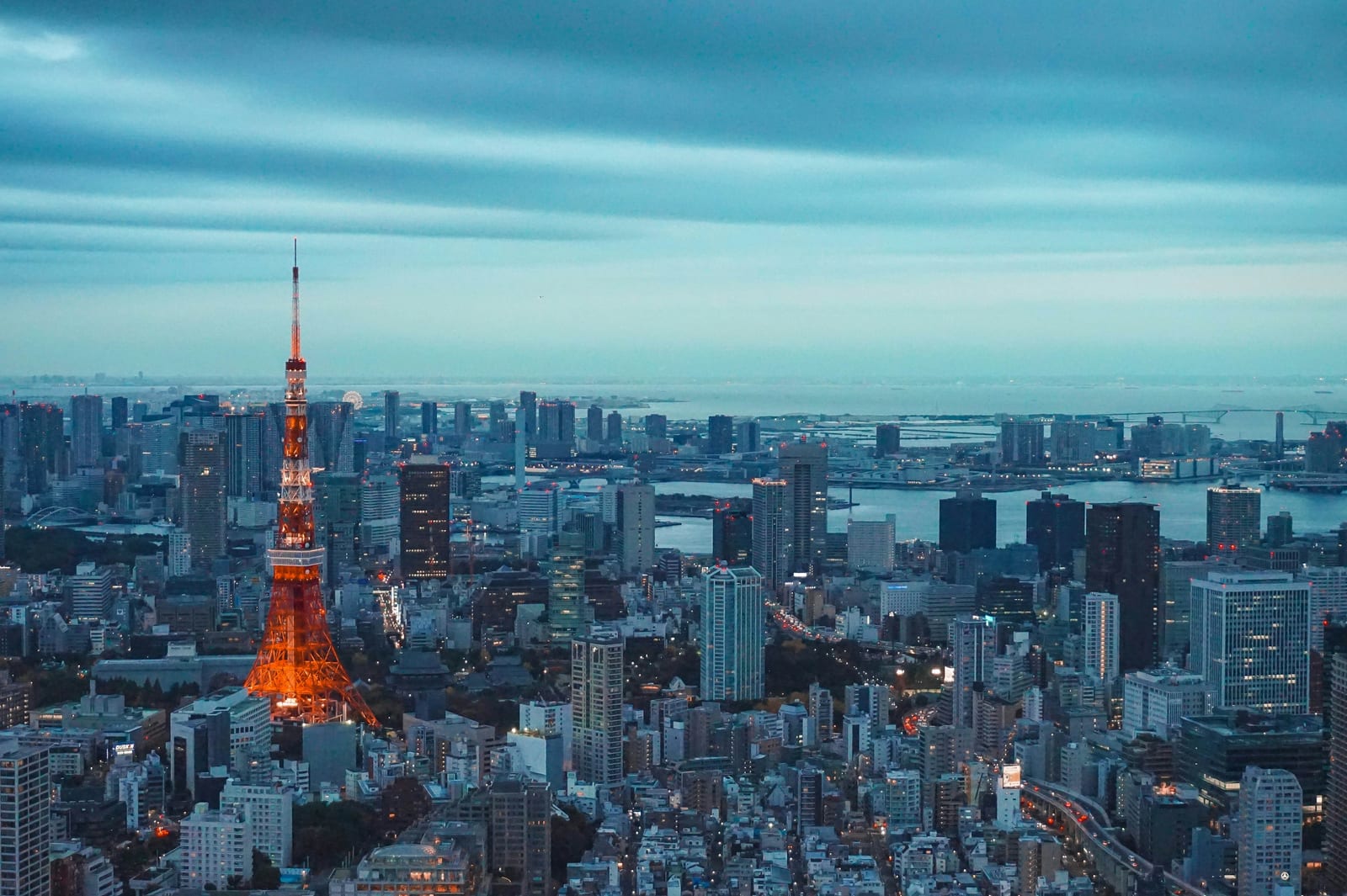 Tokyo Tower glowing at dusk above the city skyline.