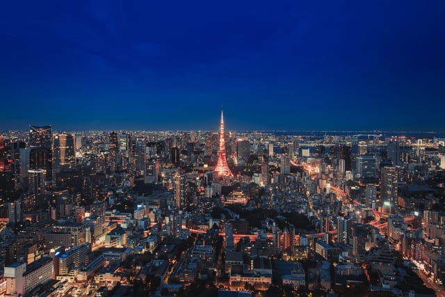 Tokyo Tower lit up above the Roppongi skyline at dusk