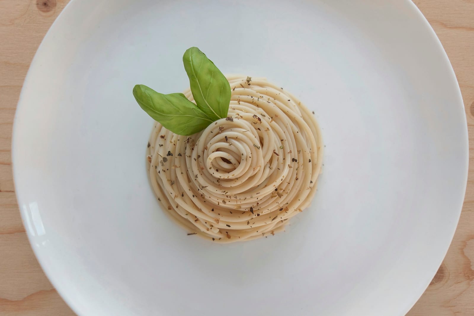 A plate of tonnarelli cacio e pepe, glossy with pecorino and black pepper.