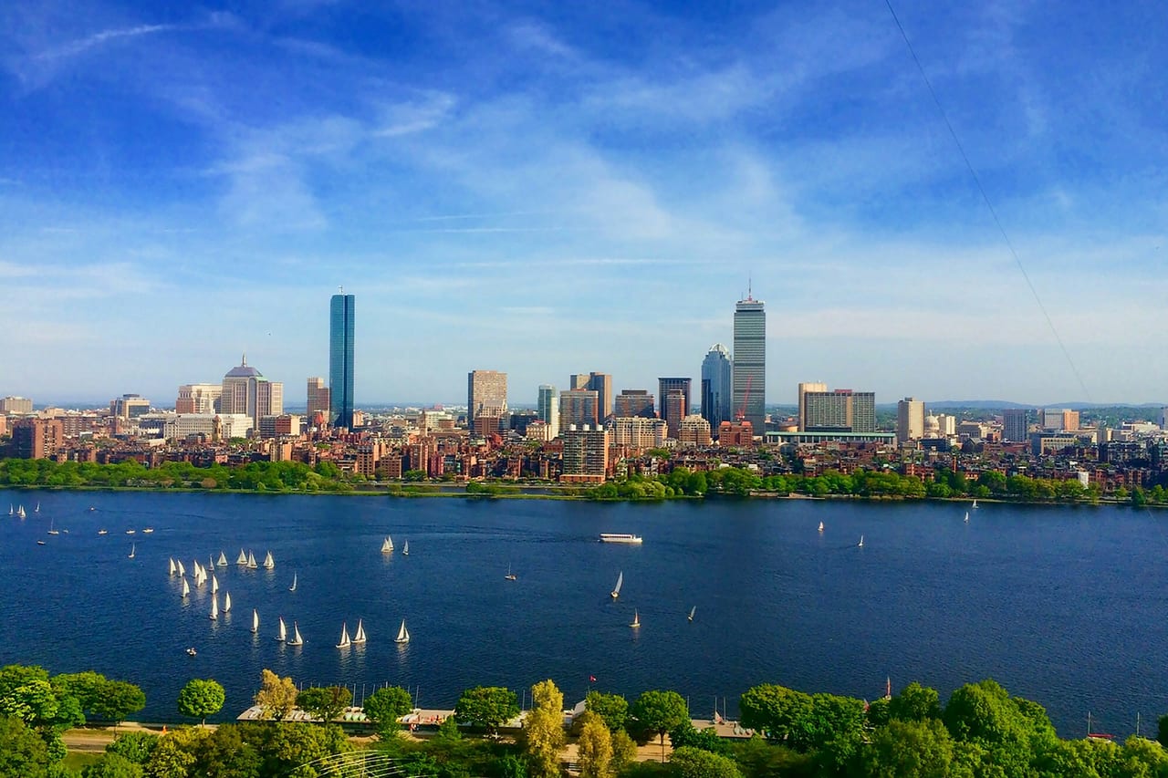 The Boston skyline and harbor seen from across the water on a clear day.