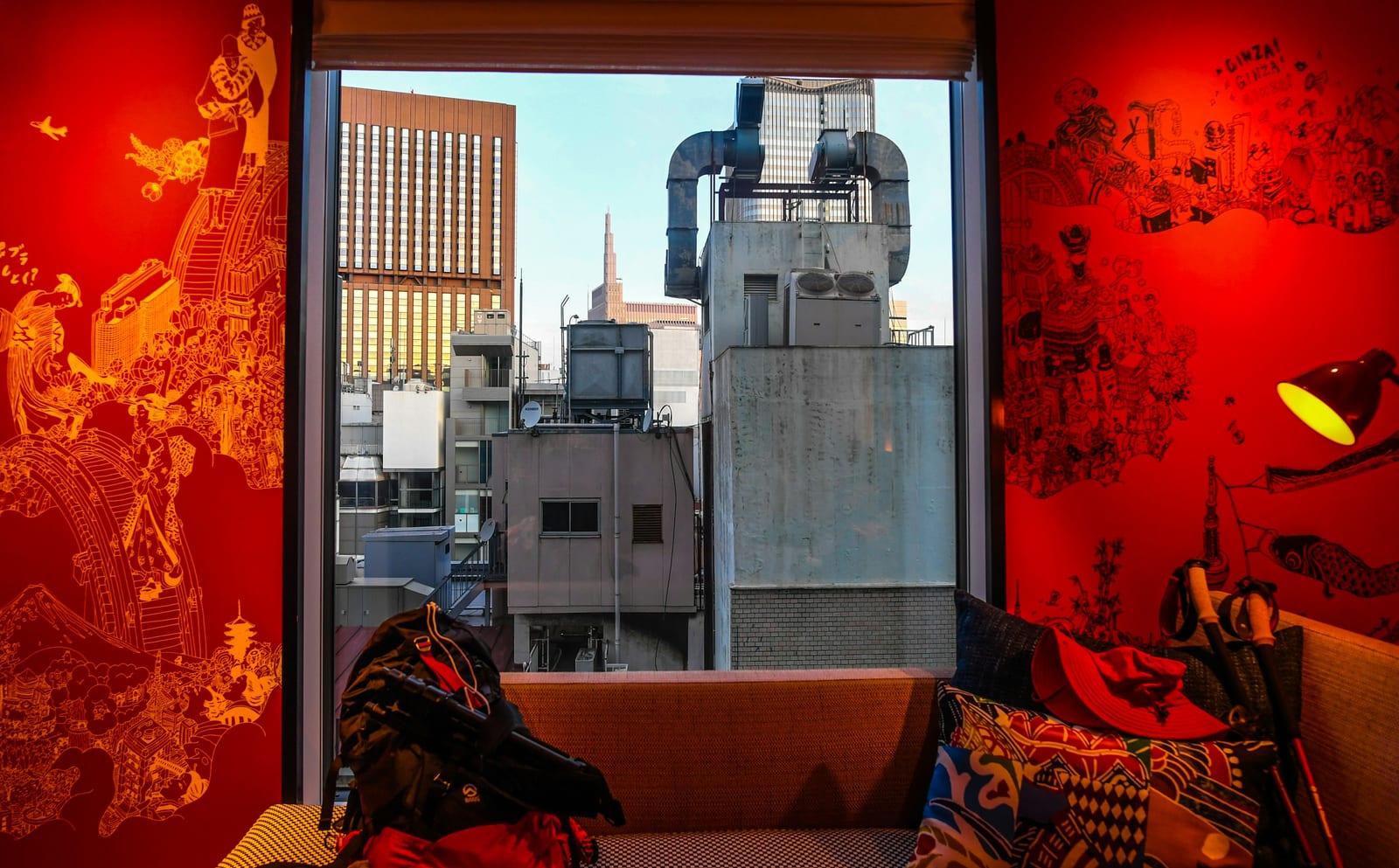 A modern Tokyo hotel room with floor-to-ceiling windows over the city at dusk.