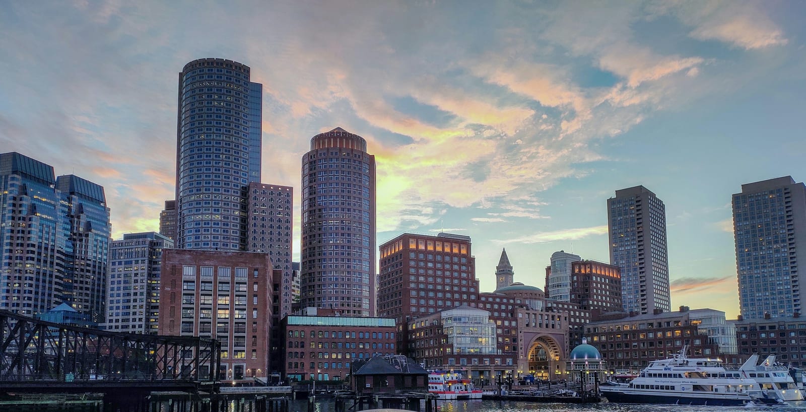Boston skyline and harbor from the waterfront, brick wharves in the foreground and the financial district rising behind them
