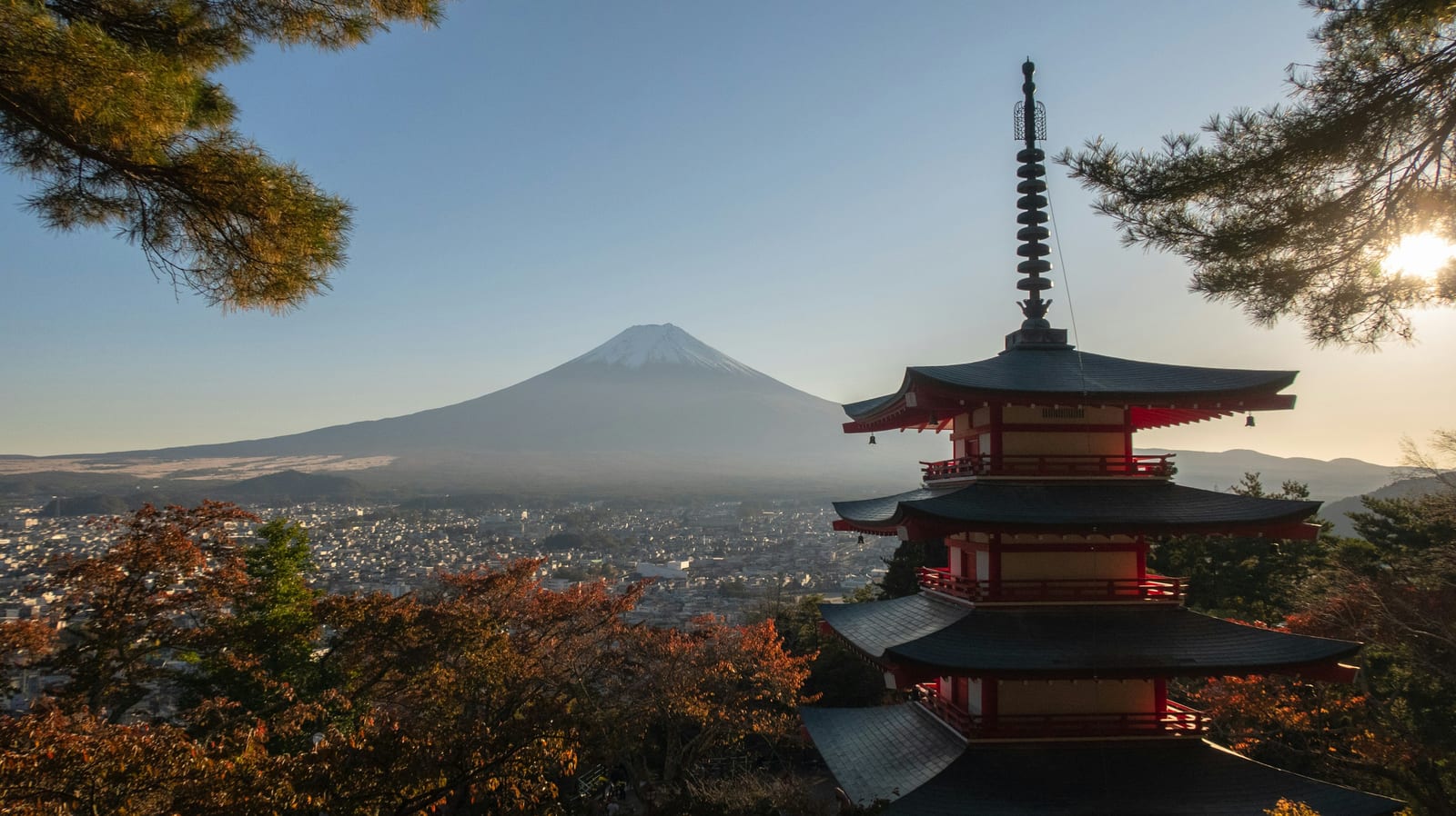The five-storey Chureito Pagoda with Mt. Fuji and cherry blossom behind it.