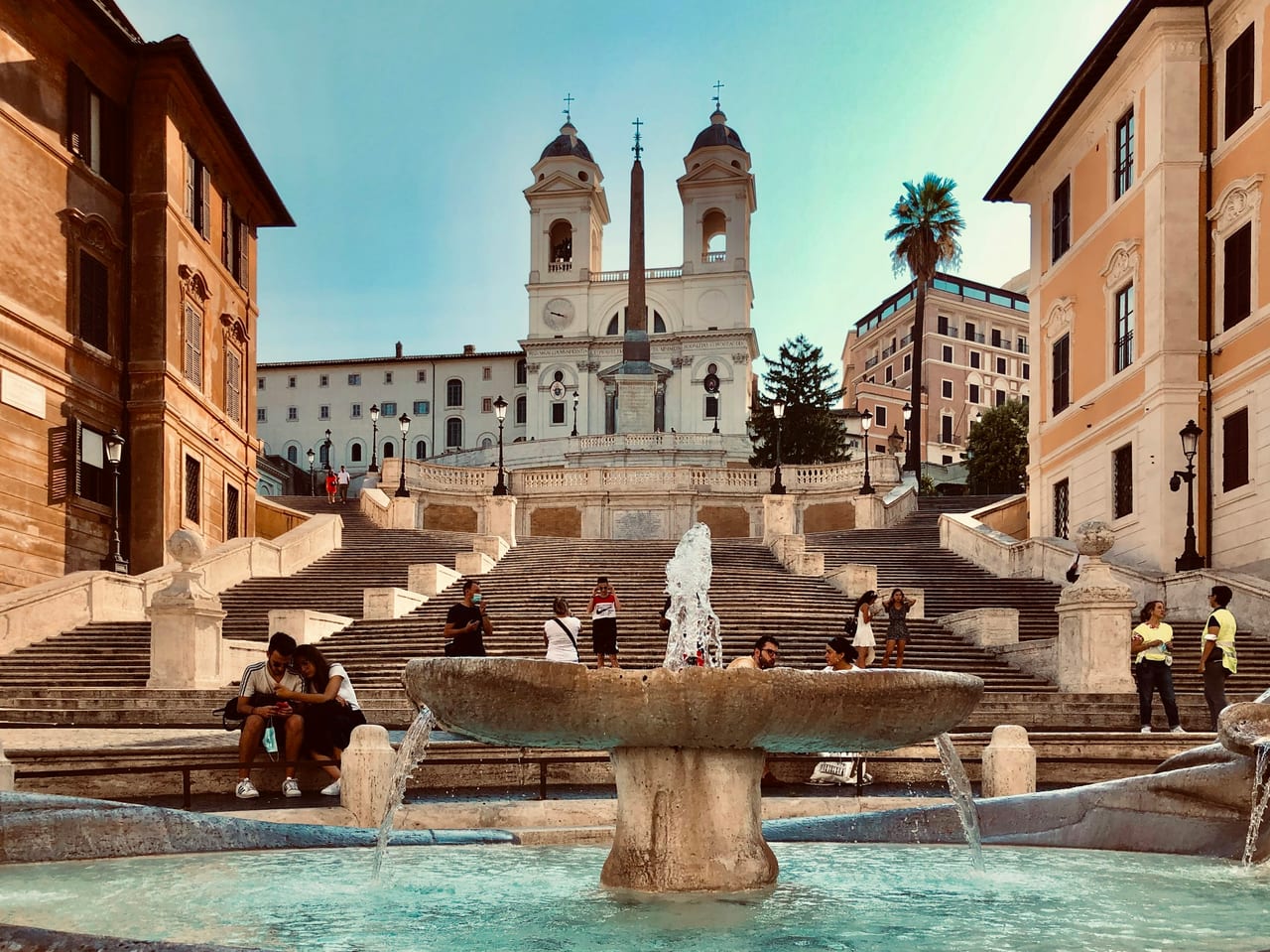 The Barcaccia fountain sits at the foot of the Spanish Steps, which climb to the twin-towered Trinita dei Monti at dawn.
