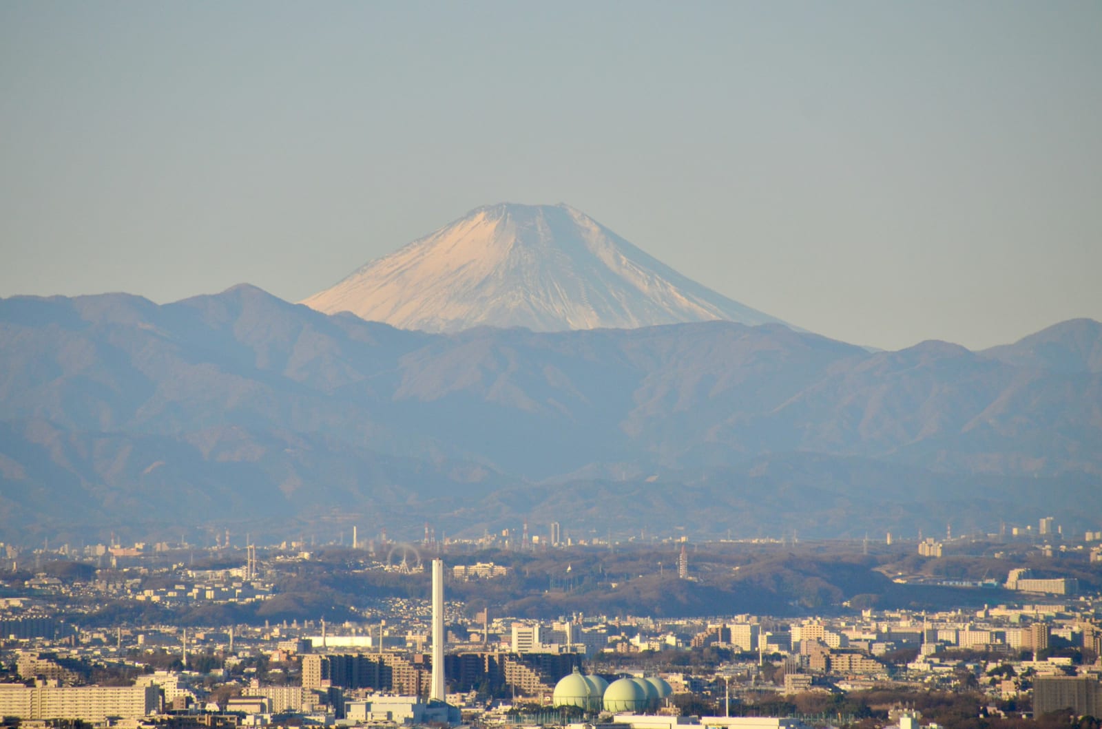 Snow-capped Mt. Fuji rising over the Tokyo cityscape on a clear day.