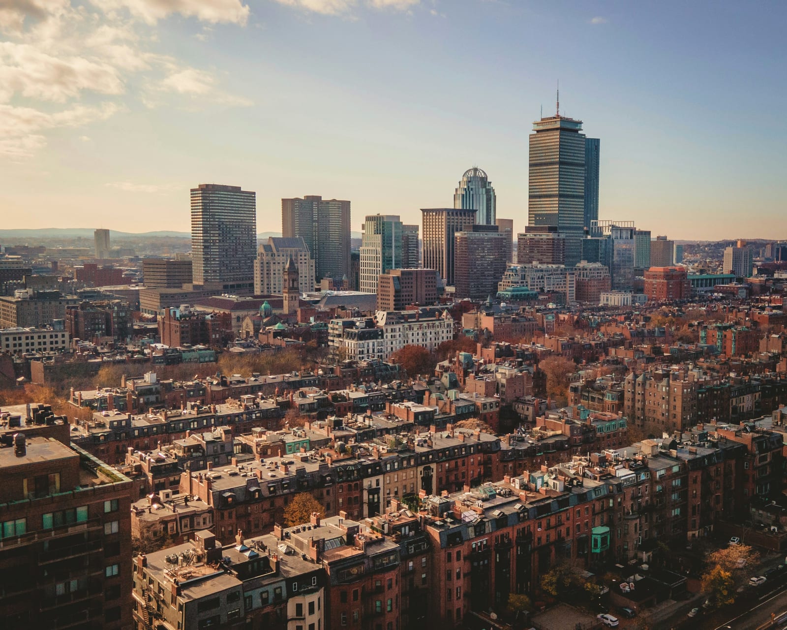 An aerial view of Back Bay brownstone blocks beneath the Boston skyline.