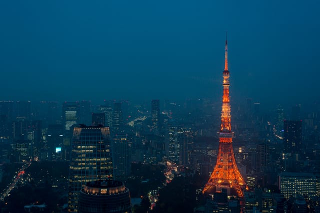 Tokyo Tower lit up above the Roppongi skyline at dusk