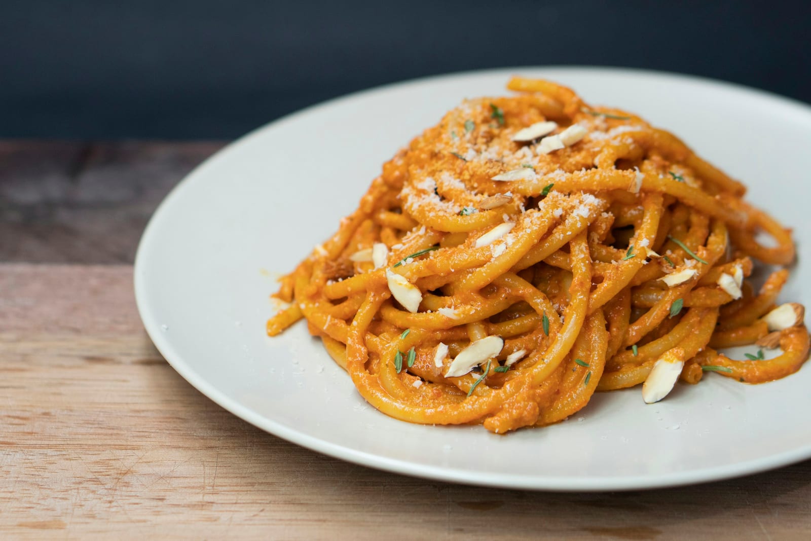 A plate of bucatini in a rich red tomato and guanciale sauce, the Roman amatriciana.