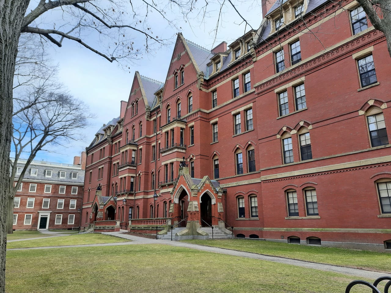 The red-brick buildings and green lawns of Harvard Yard on a clear autumn day in Cambridge.