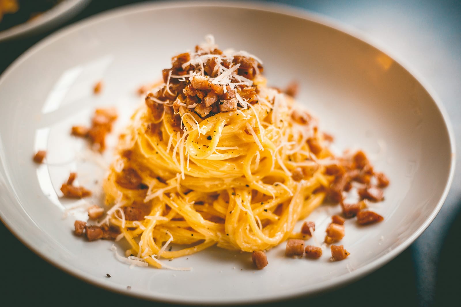 A bowl of Roman carbonara, glossy with egg yolk, pecorino and crisp guanciale.
