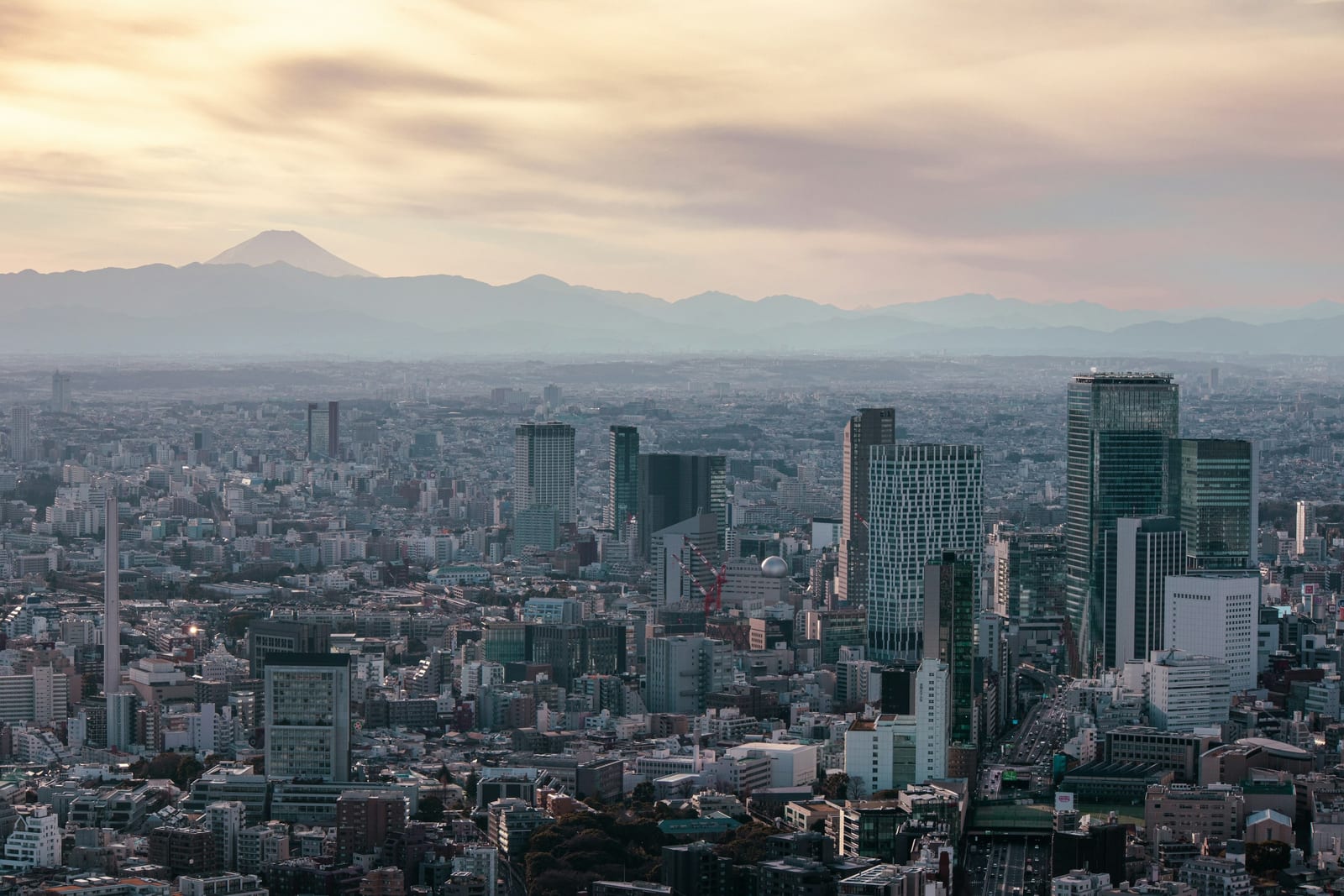 Snow-capped Mt. Fuji beyond the Tokyo cityscape on a clear winter day.