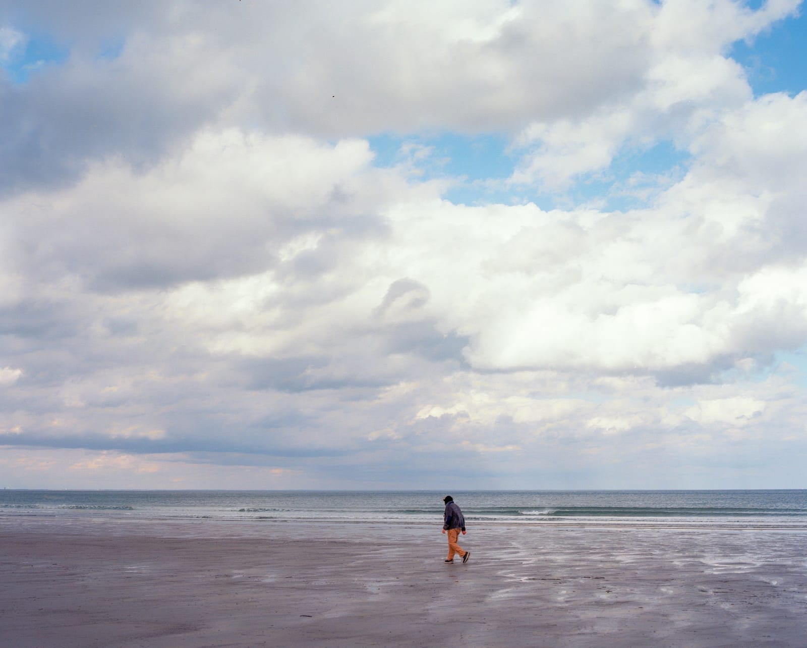 A wide sandy beach with gentle waves on a summer day.