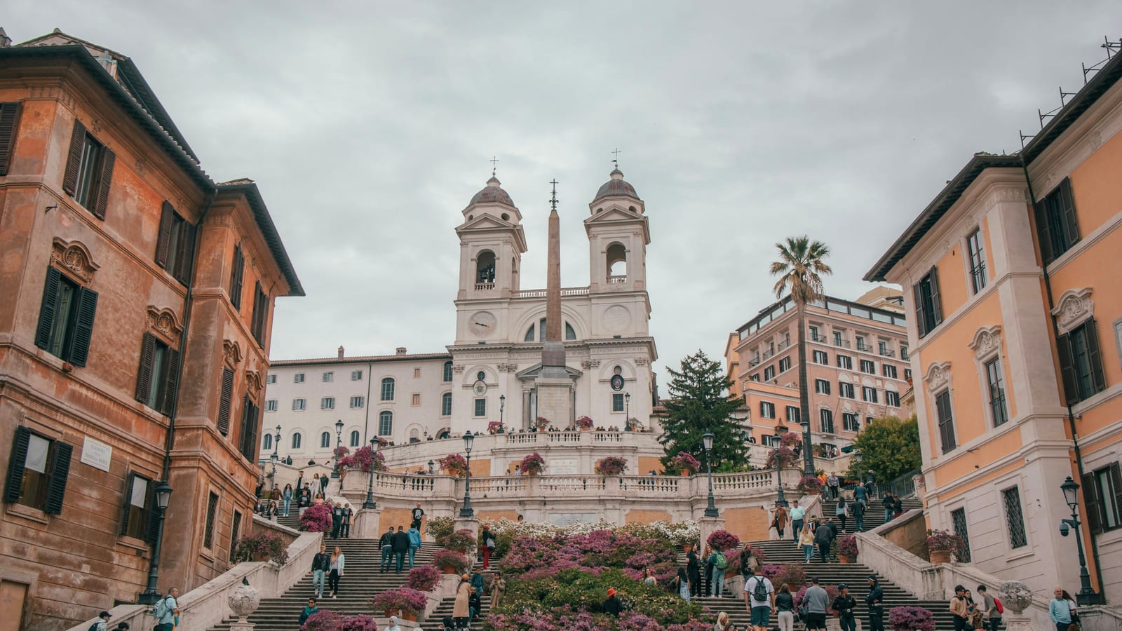 The Spanish Steps lined with blooming pink azaleas beneath the twin towers of Trinita dei Monti.