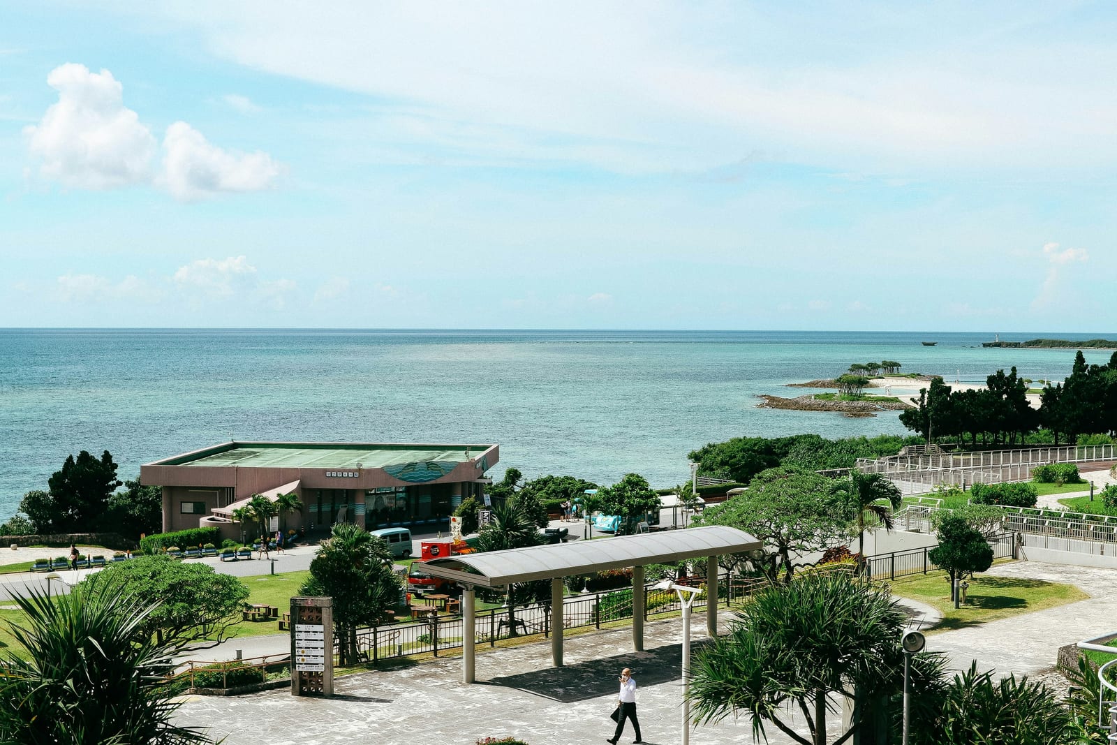 A building with a pool and trees by the ocean in Onna