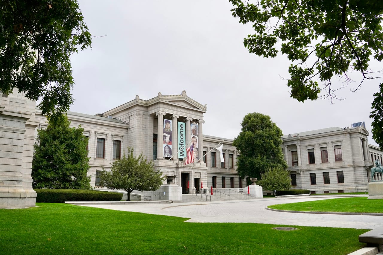 The columned entrance of the Museum of Fine Arts, Boston, seen from Huntington Avenue on a sunny afternoon.