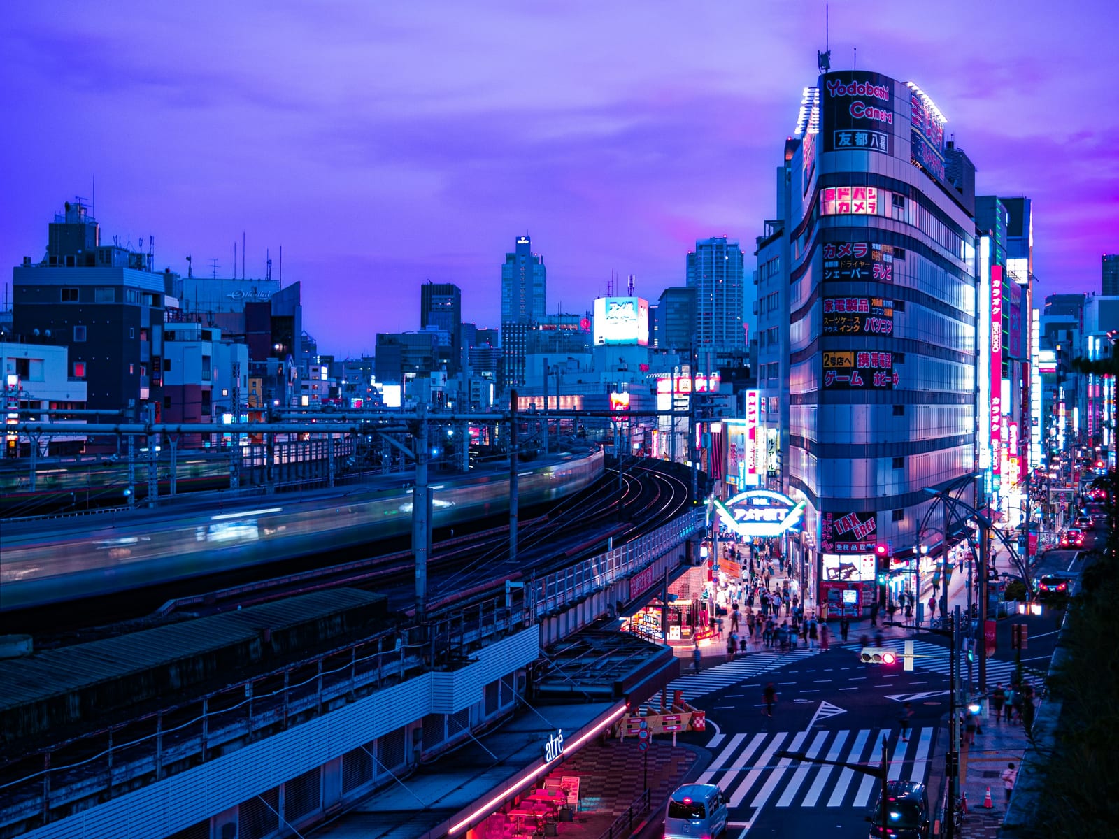 Akihabara's neon-lit Chuo-dori avenue at dusk.