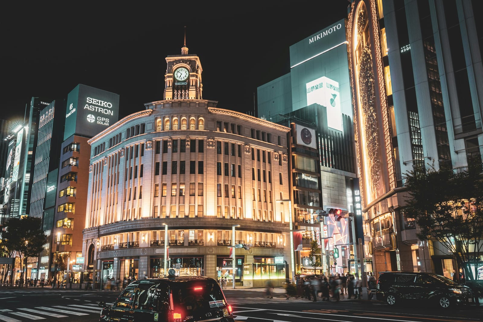 The Wako clock tower lit at dusk above the Ginza 4-chome crossing.