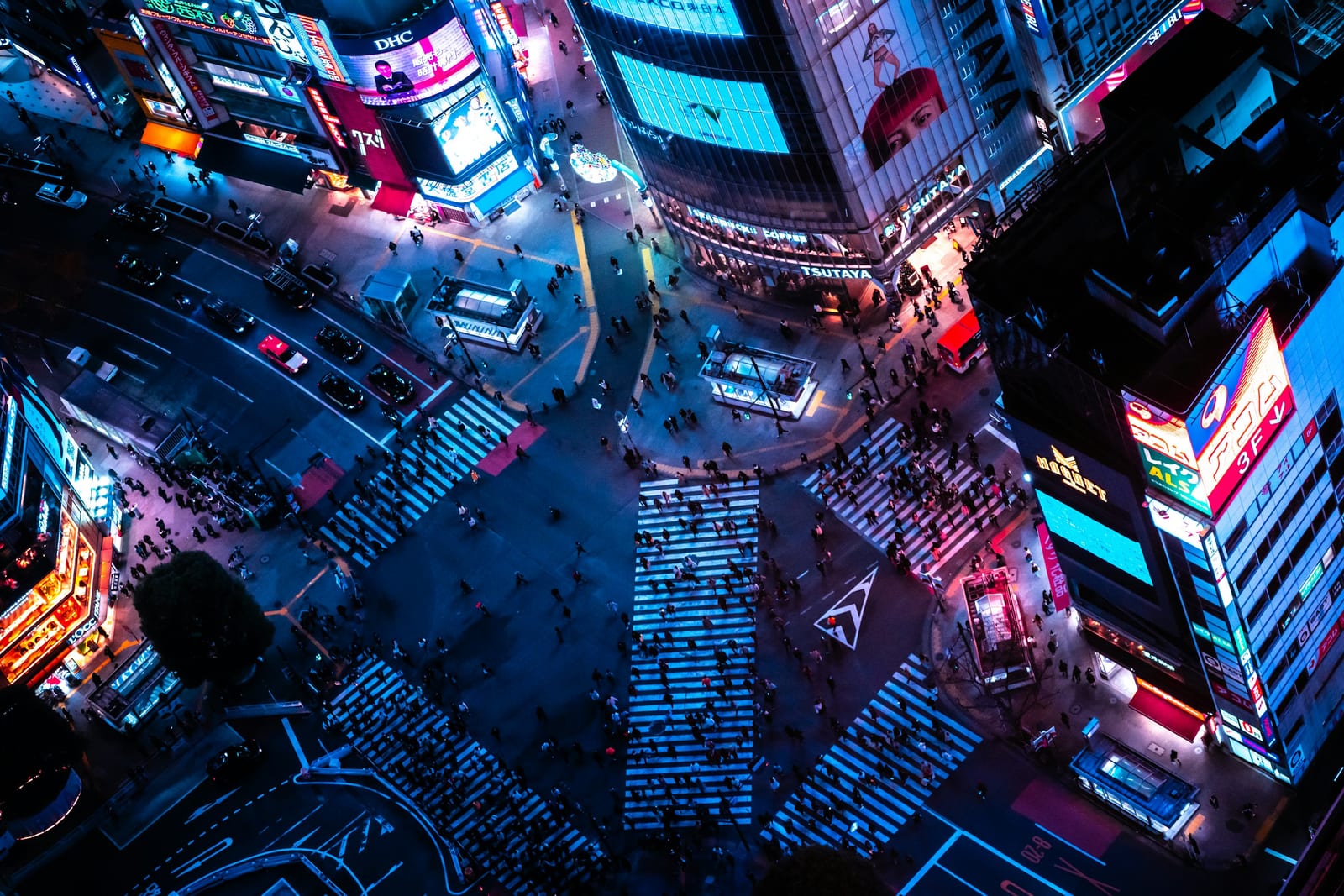 Shibuya Crossing lit up at night from above