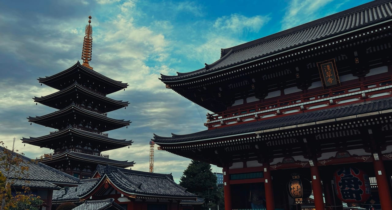 Senso-ji's red gate and five-story pagoda stand against a clear blue sky in Asakusa.