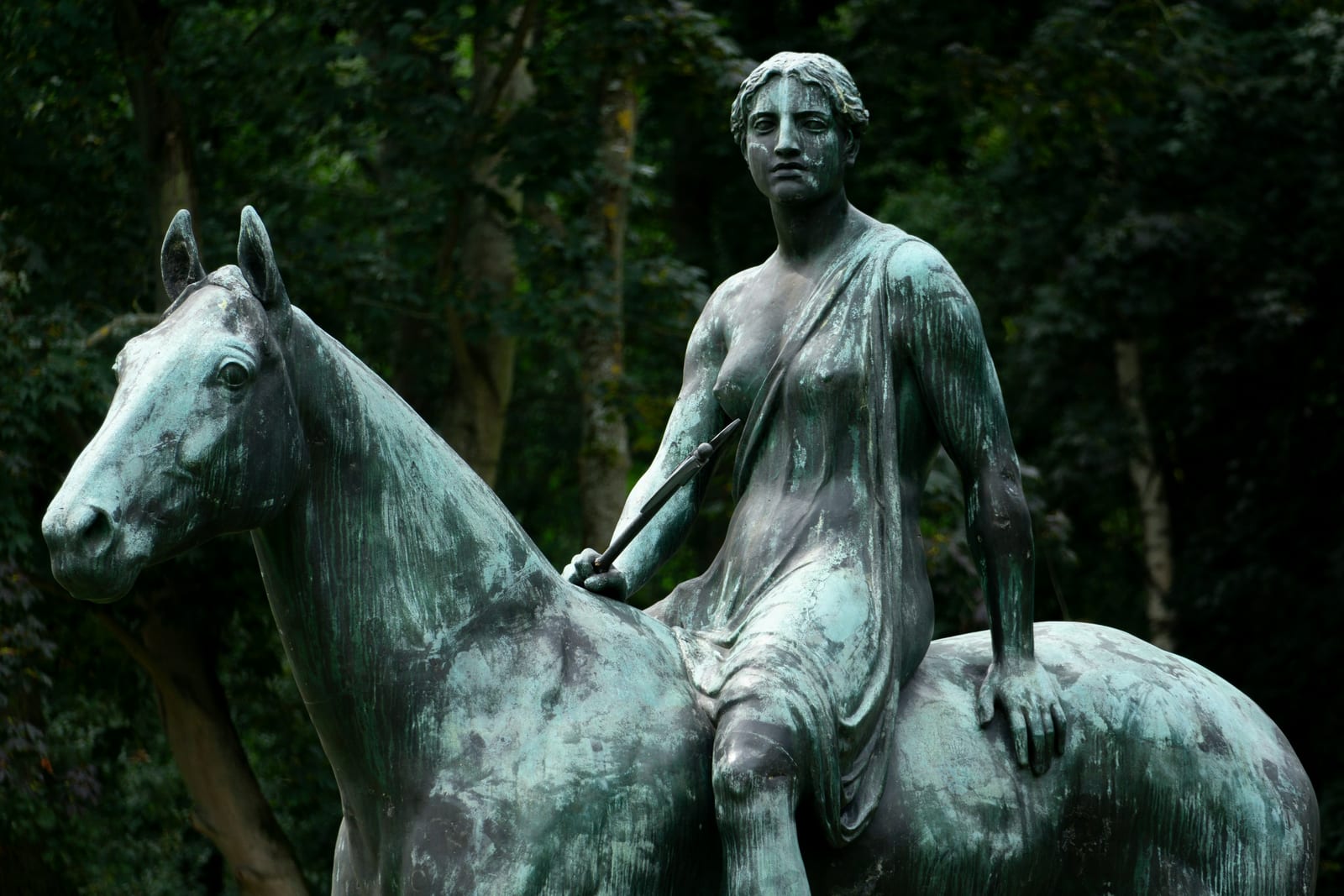 A marble equestrian sculpture group in a Roman park.