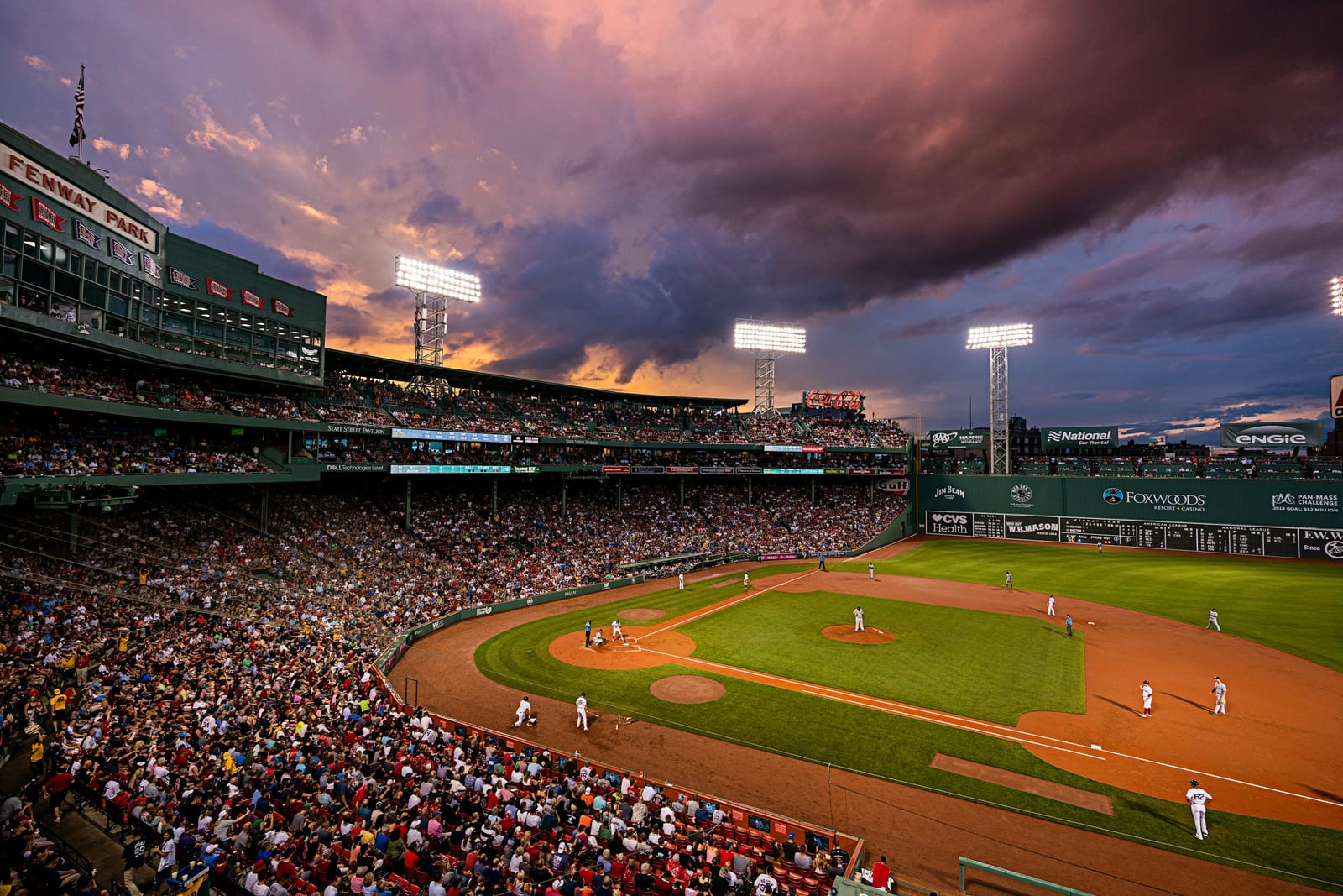 Fenway Park during a Red Sox game, the Green Monster visible beyond the diamond